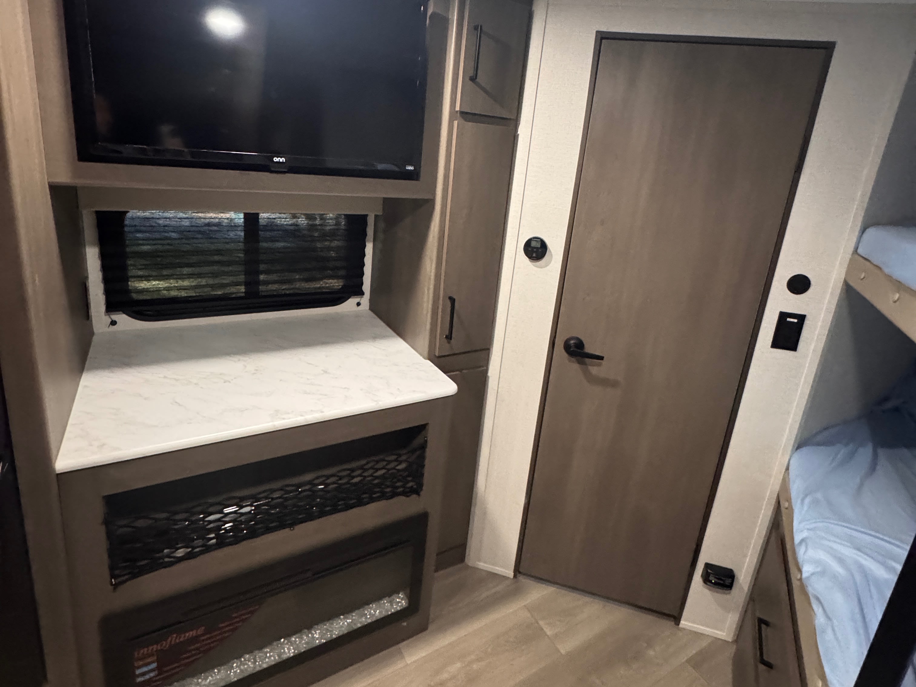 This rv rental offers a built-in TV, electric fireplace, counter space, and bunk beds, perfect for family adventures.. Grand Design Transcend Xplor 2025