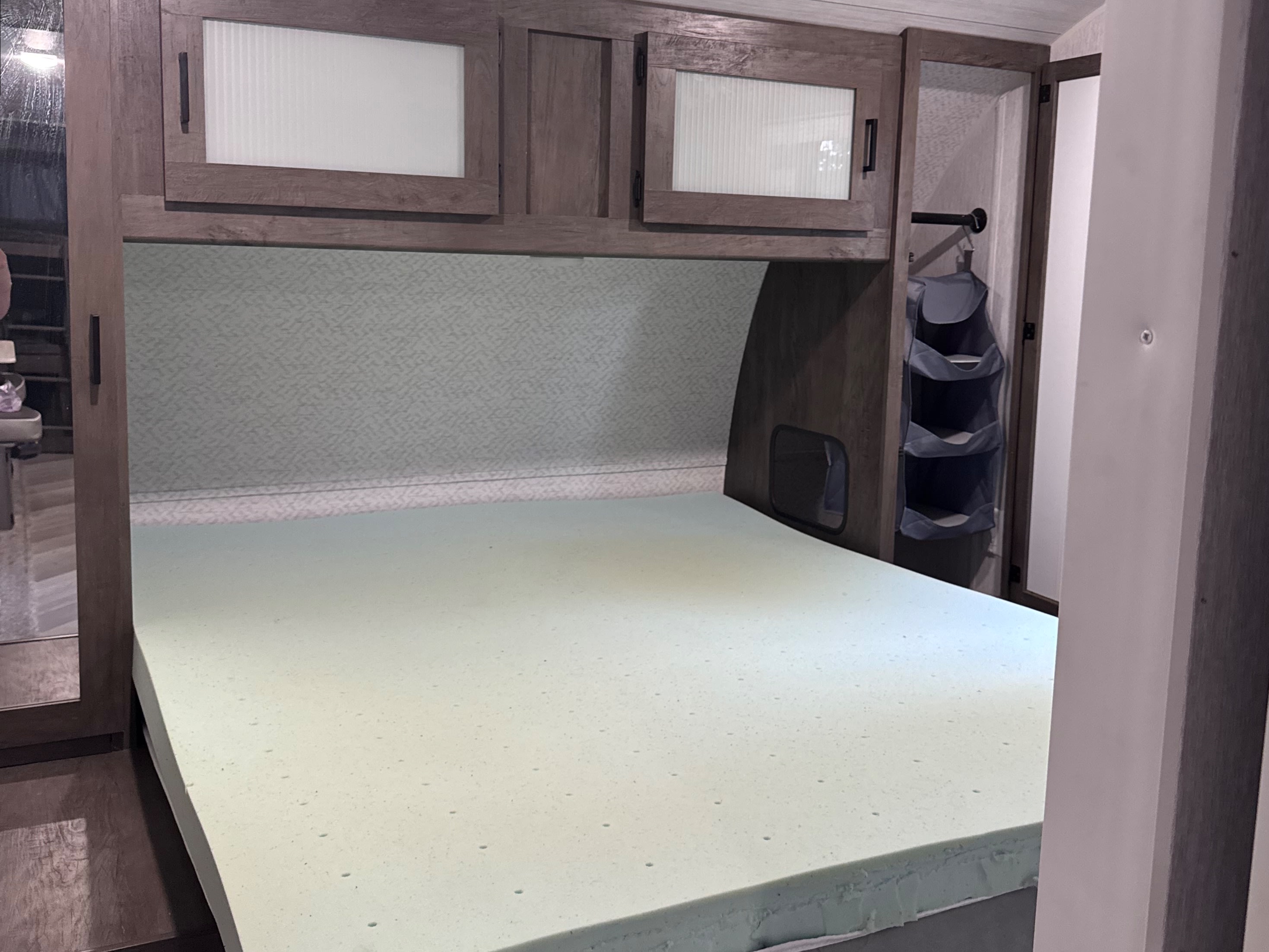 Cozy RV rental bedroom with a comfy foam mattress, overhead storage, & closet organizer, perfect for your next adventure.. Forest River Wildwood 2022