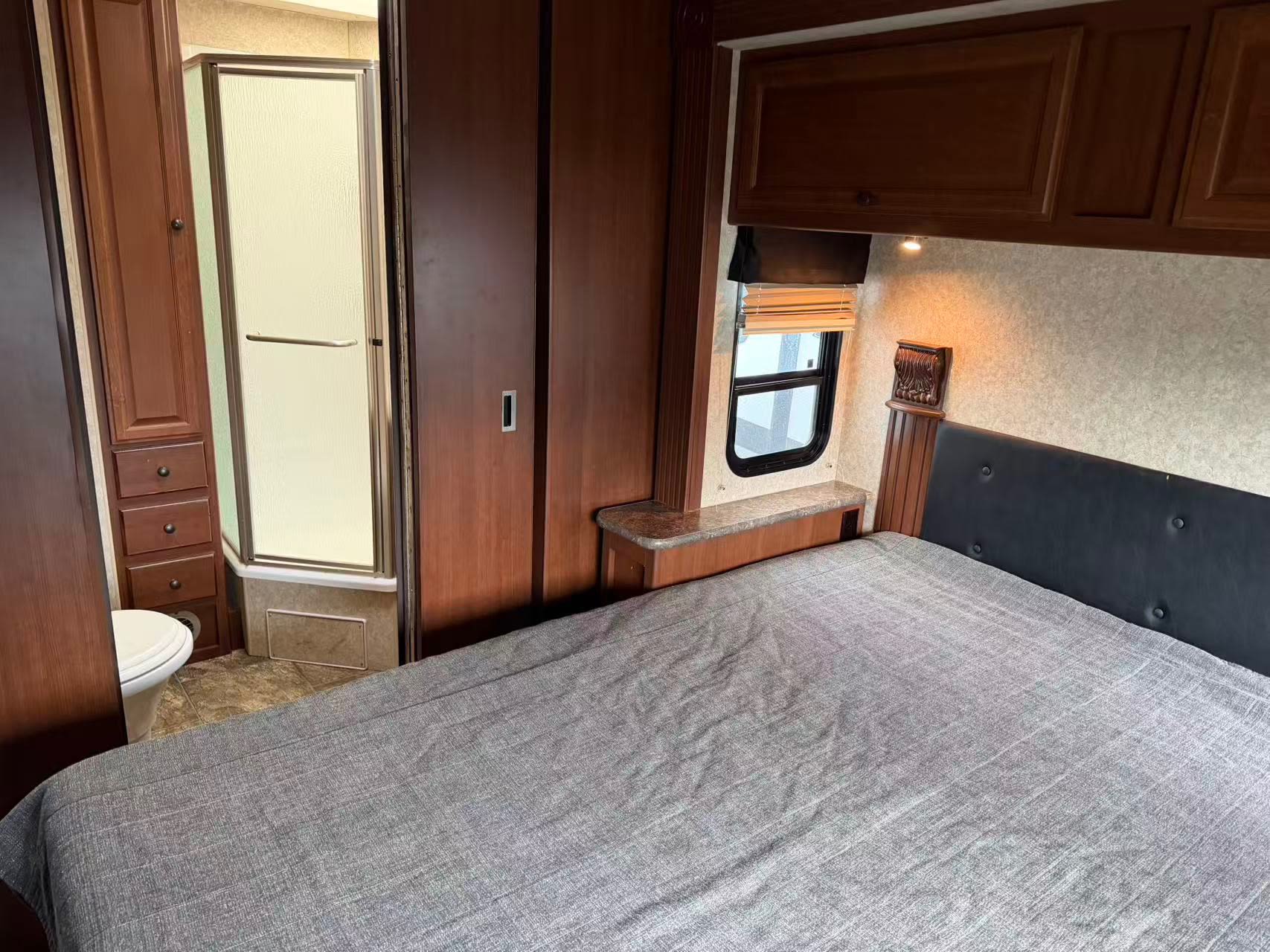 Cozy RV rental bedroom with queen bed, private shower, and toilet. Ideal for comfortable travel adventures.. Tioga Montara 2013