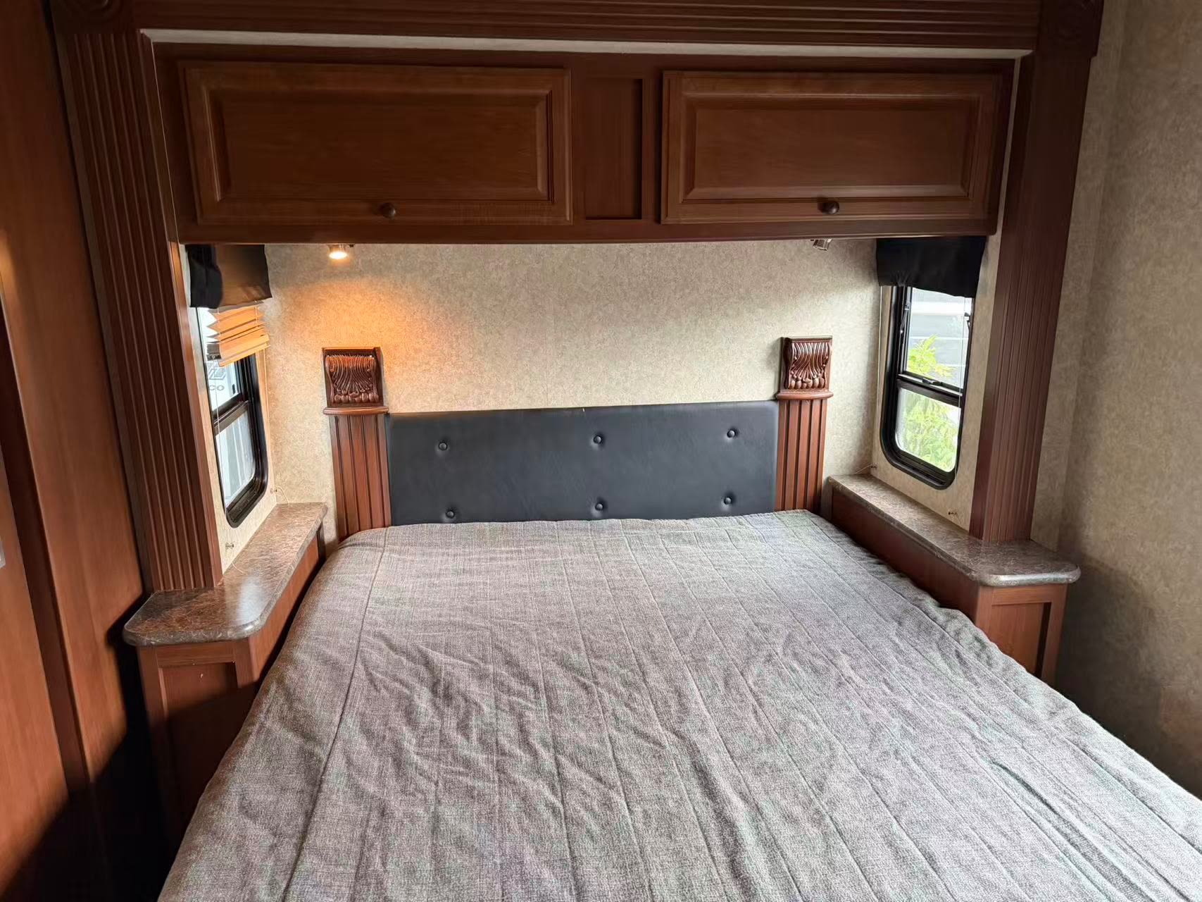 RV rental master bedroom featuring a comfy queen bed, overhead storage, and side windows.. Tioga Montara 2013