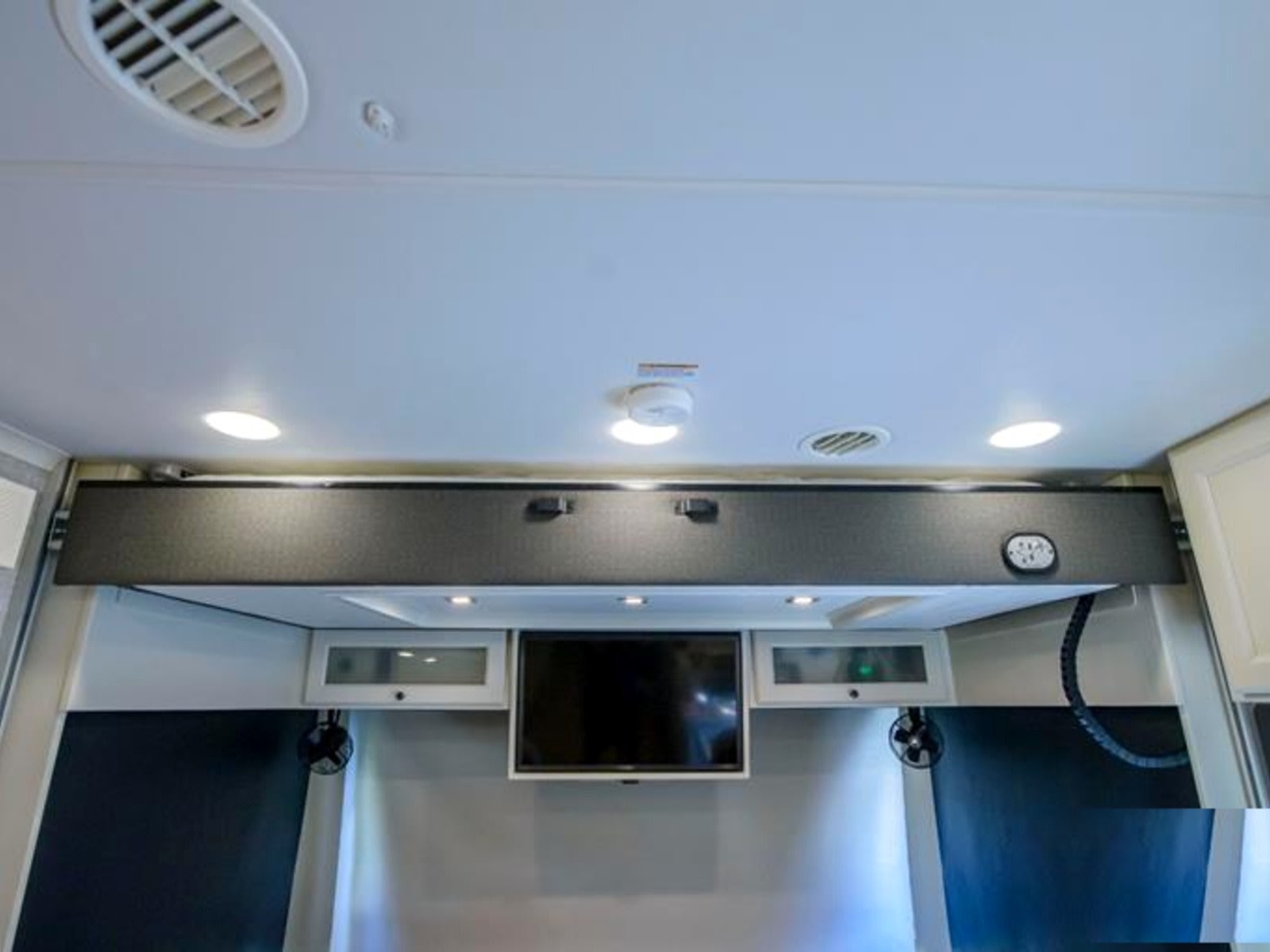 This rv rental's interior features an overhead bunk, TV, and cabinets with fans. The ceiling has recessed lights and air vents.. Allegro Allegro Open Road 2025