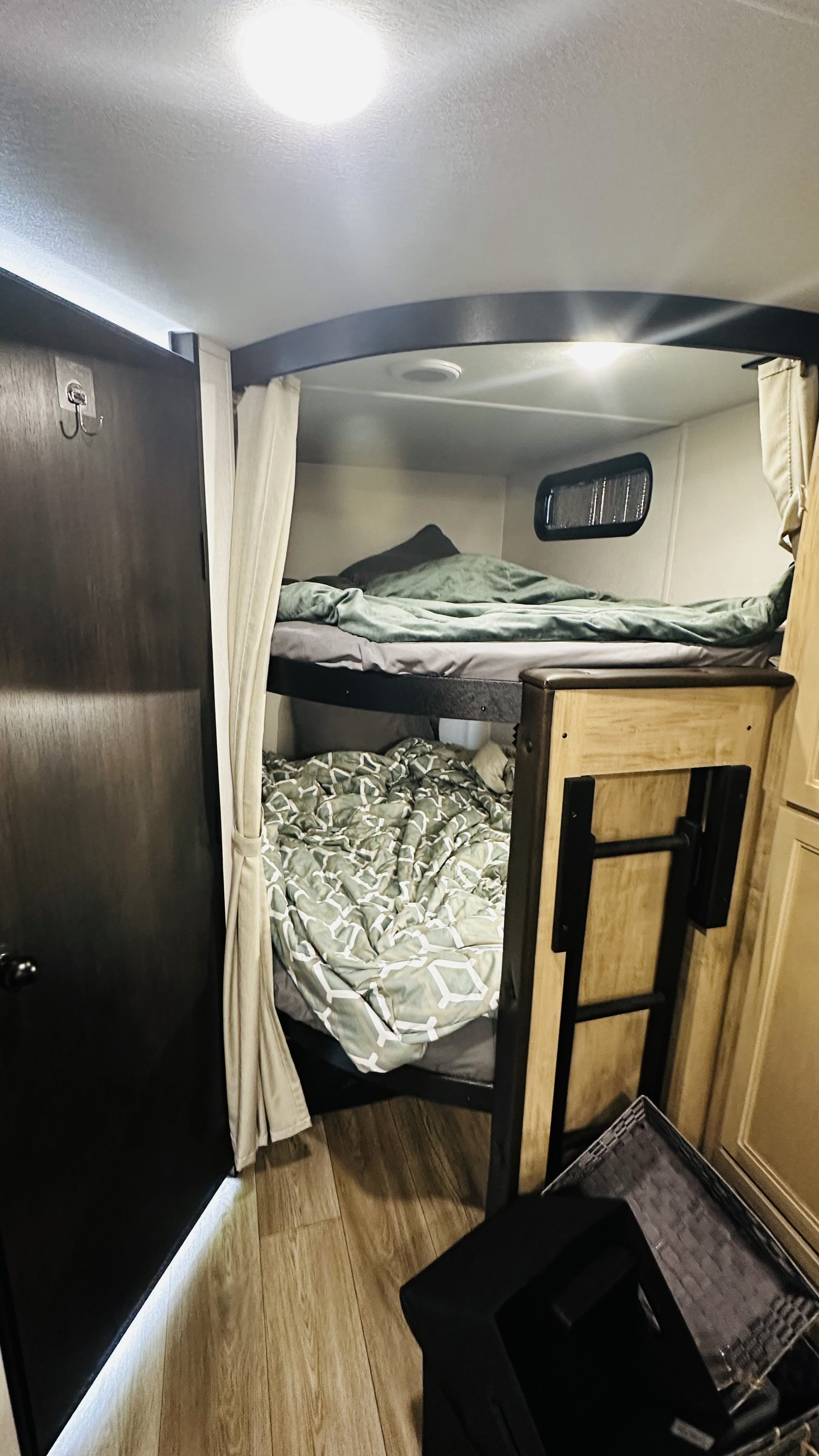 Inside an RV rental: two bunk beds with cozy bedding and privacy curtains, offering a compact and comfortable sleeping area.. Forest River Cherokee Grey Wolf 2027