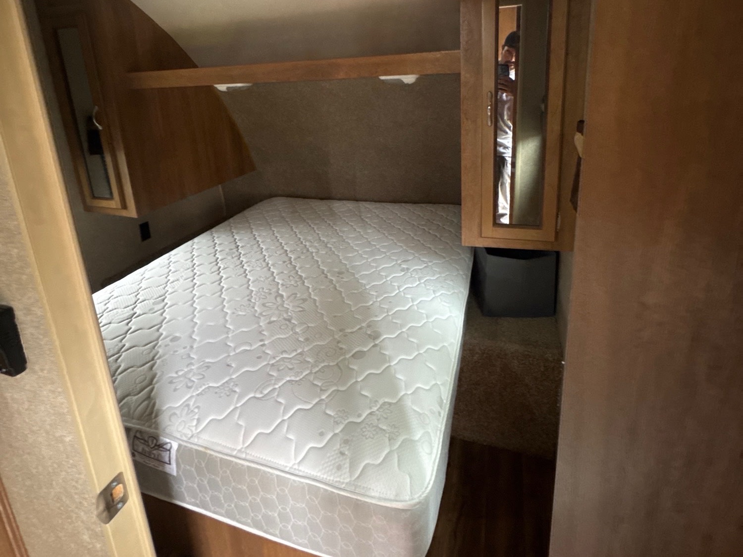 RV rental bedroom with white mattress, overhead cabinets, and mirrored wardrobe for compact sleeping.. Coachmen Catalina 2016