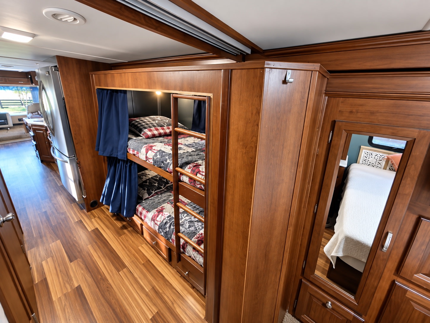 Explore a comfortable RV rental interior: bunk beds with curtains, a kitchen, and a mirrored master bedroom view.. Georgetown Georgetown Motorhome 2014