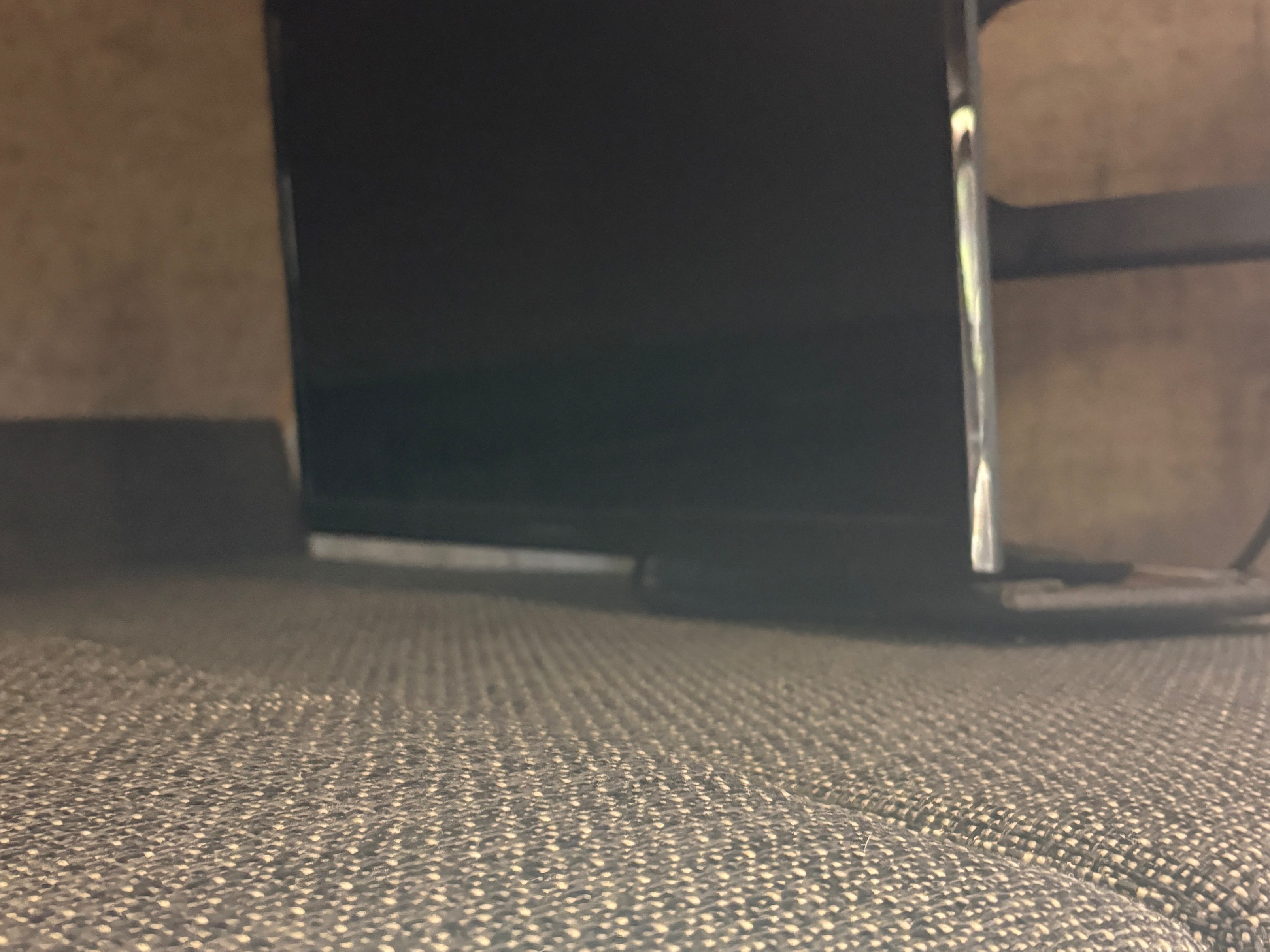 Low view of an RV rental interior, showing a TV screen and textured upholstery, likely under a bed or couch.. Forest River Coachmen Prism 2018