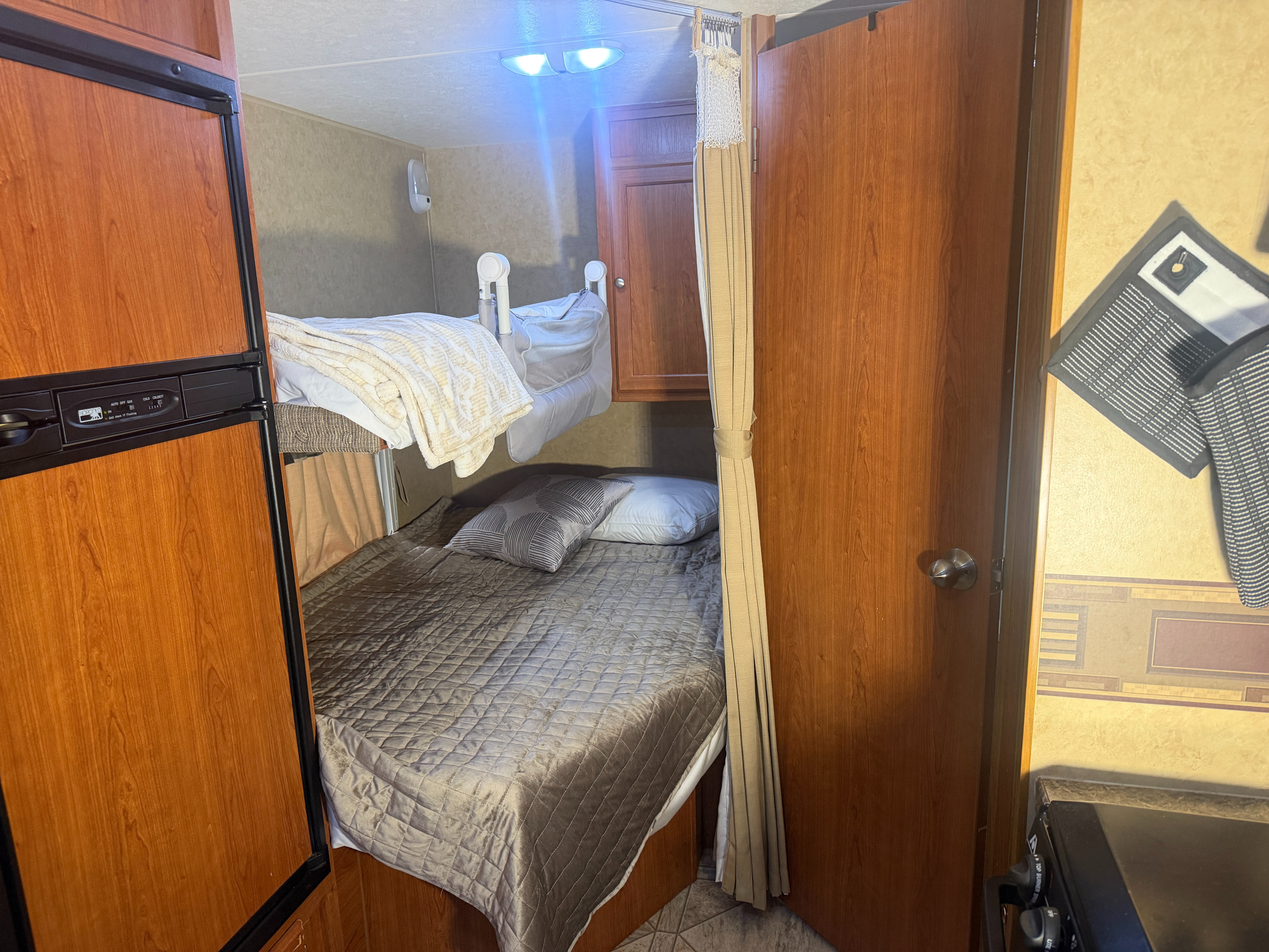 This RV rental interior features bunk beds, a refrigerator, and a small kitchen area for a comfortable camper experience.. R-Vision 21RBH trail-Cruiser 2009
