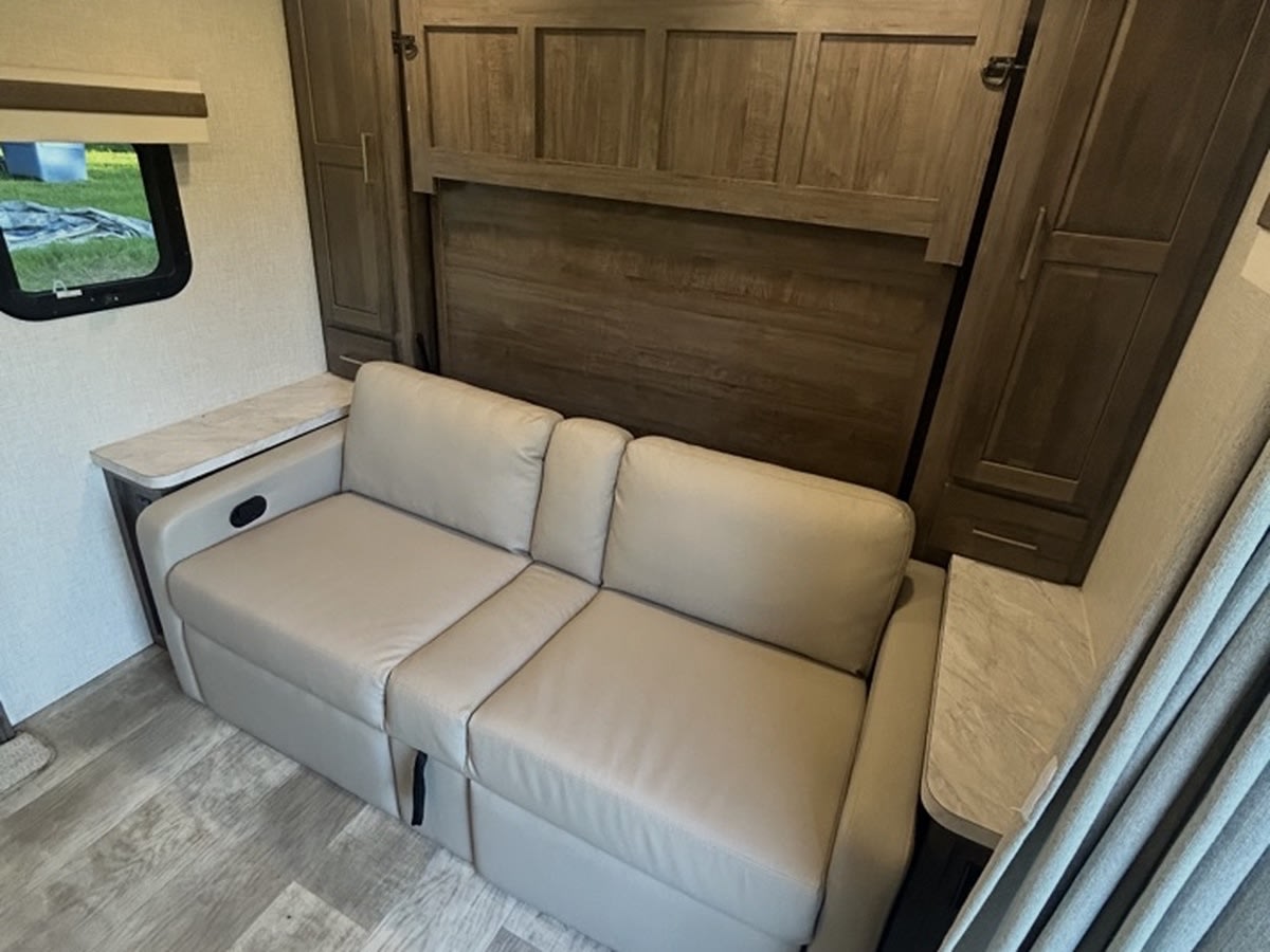 RV rental: Compact interior with a light sofa-bed and integrated wall bed unit, offering versatile sleeping and living space.. Rockwood Mini Lite 2104S 2023