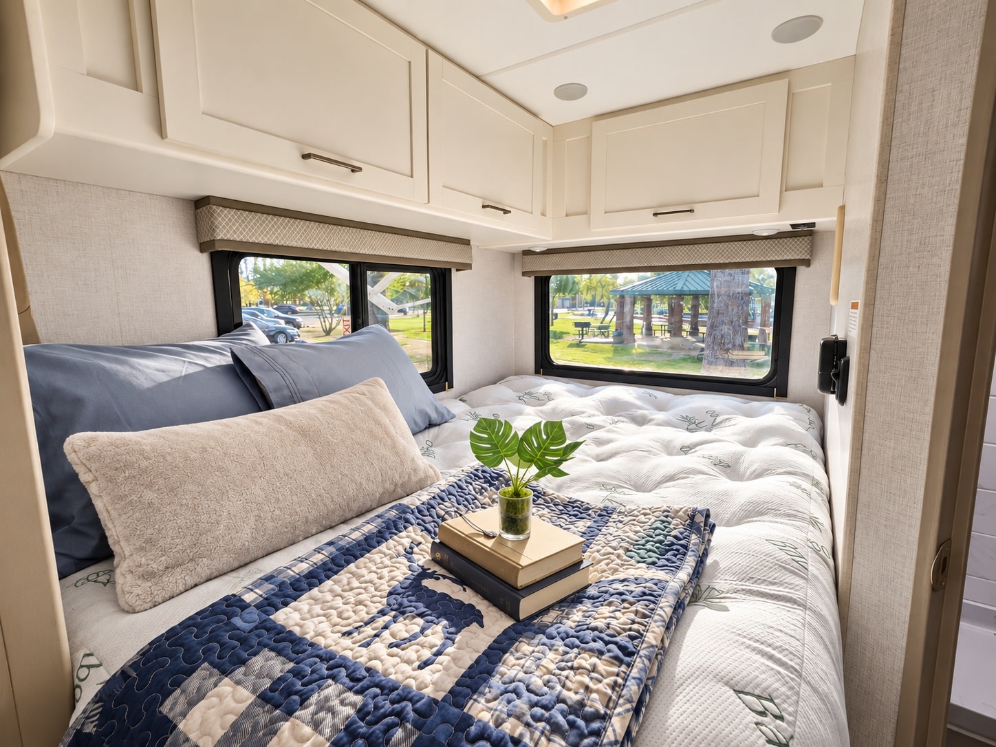 Experience comfort in this RV rental bedroom, featuring a cozy bed, ample cabinets, and scenic views from its windows.. Thor Chateau 2026
