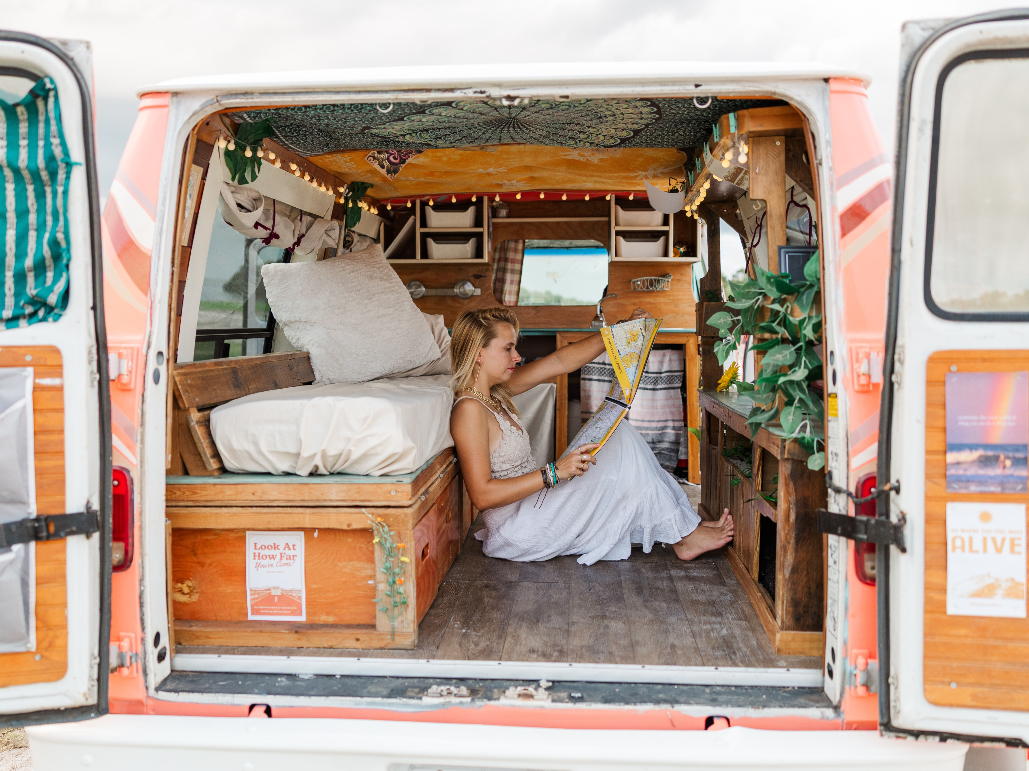Cozy RV rental adventure: Woman studies a map inside a beautifully converted camper van, perfect for road trip travel.. Chevrolet G20 Chevy Van 1990