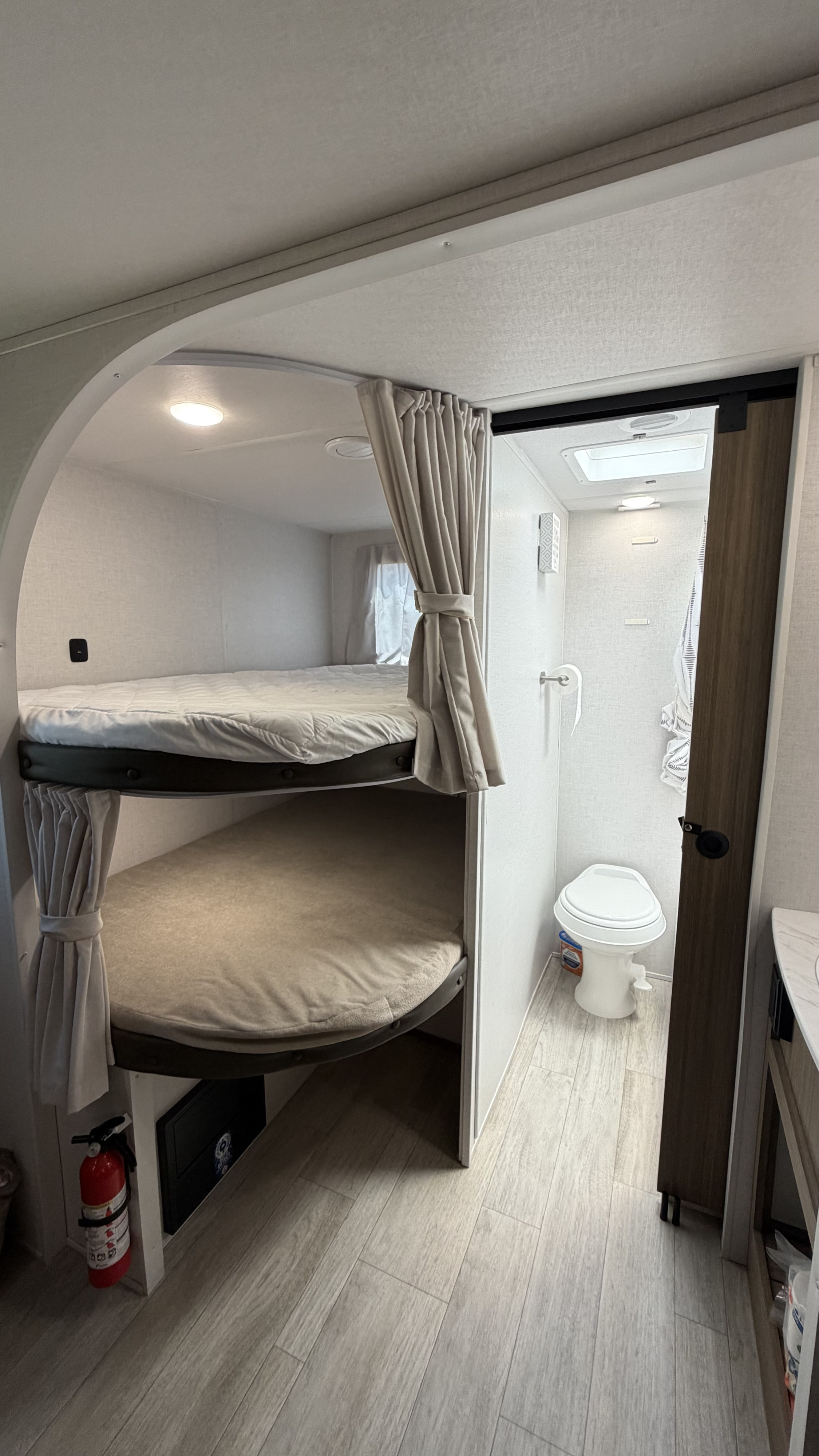 RV rental interior featuring cozy bunk beds with privacy curtains and a compact wet bath with toilet and shower.. Forest River Salem Cruise-Lite 2025