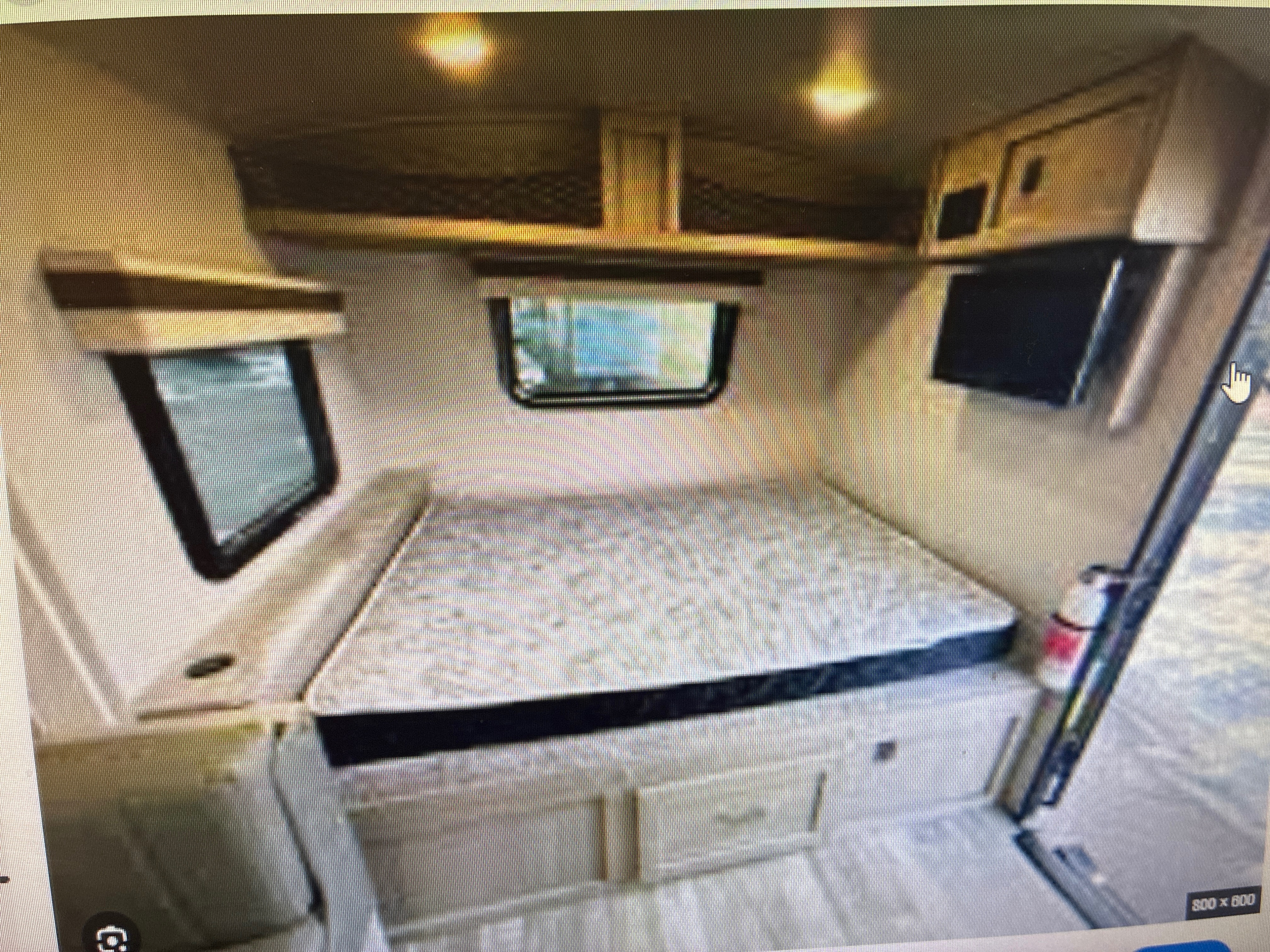 This cozy RV rental interior features a bed with under-storage, overhead cabinets, a TV, and windows, perfect for travel.. Forest River Rockwood Geo Pro 2022