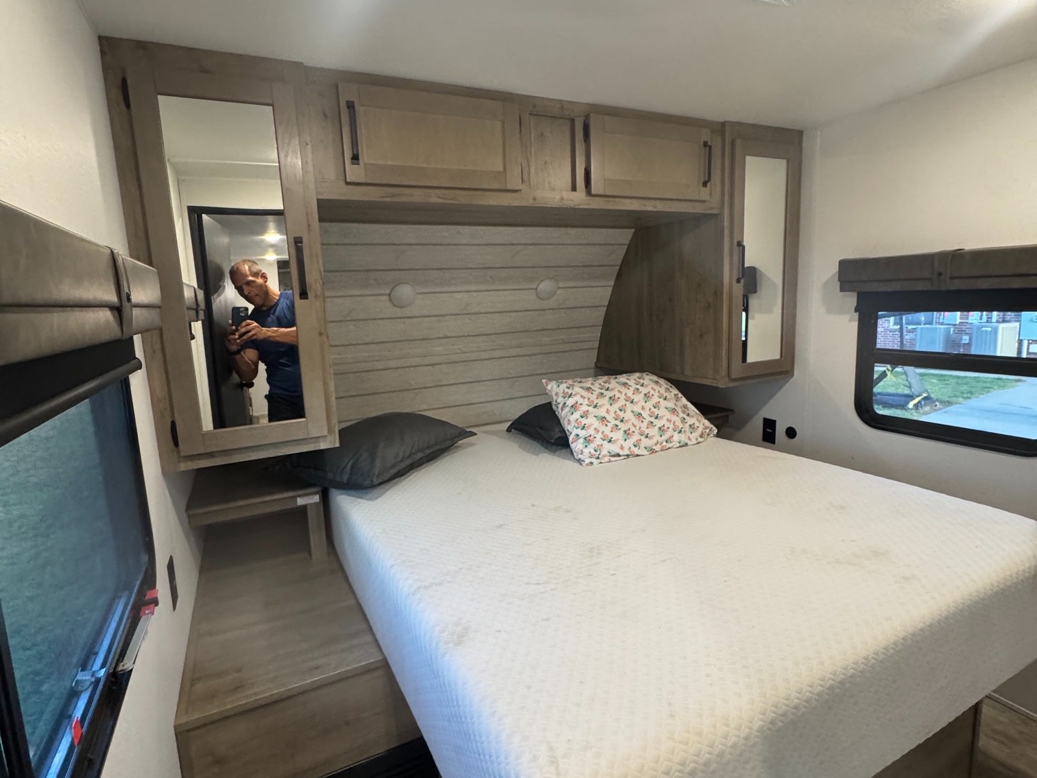 Cozy RV rental bedroom featuring a full bed, mirrored cabinet, and window. Ideal for comfortable travel & camping.. Forest River Palomino Puma 2025