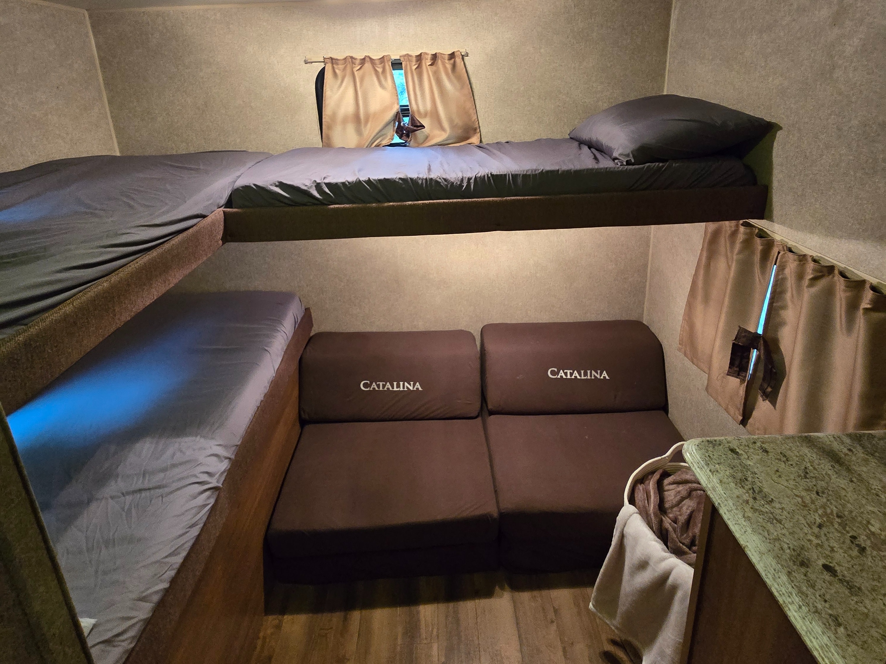 This RV rental features comfy bunk beds, a convertible Catalina sofa below, and a window. Blue light adds ambiance.. Coachmen Catalina 2017
