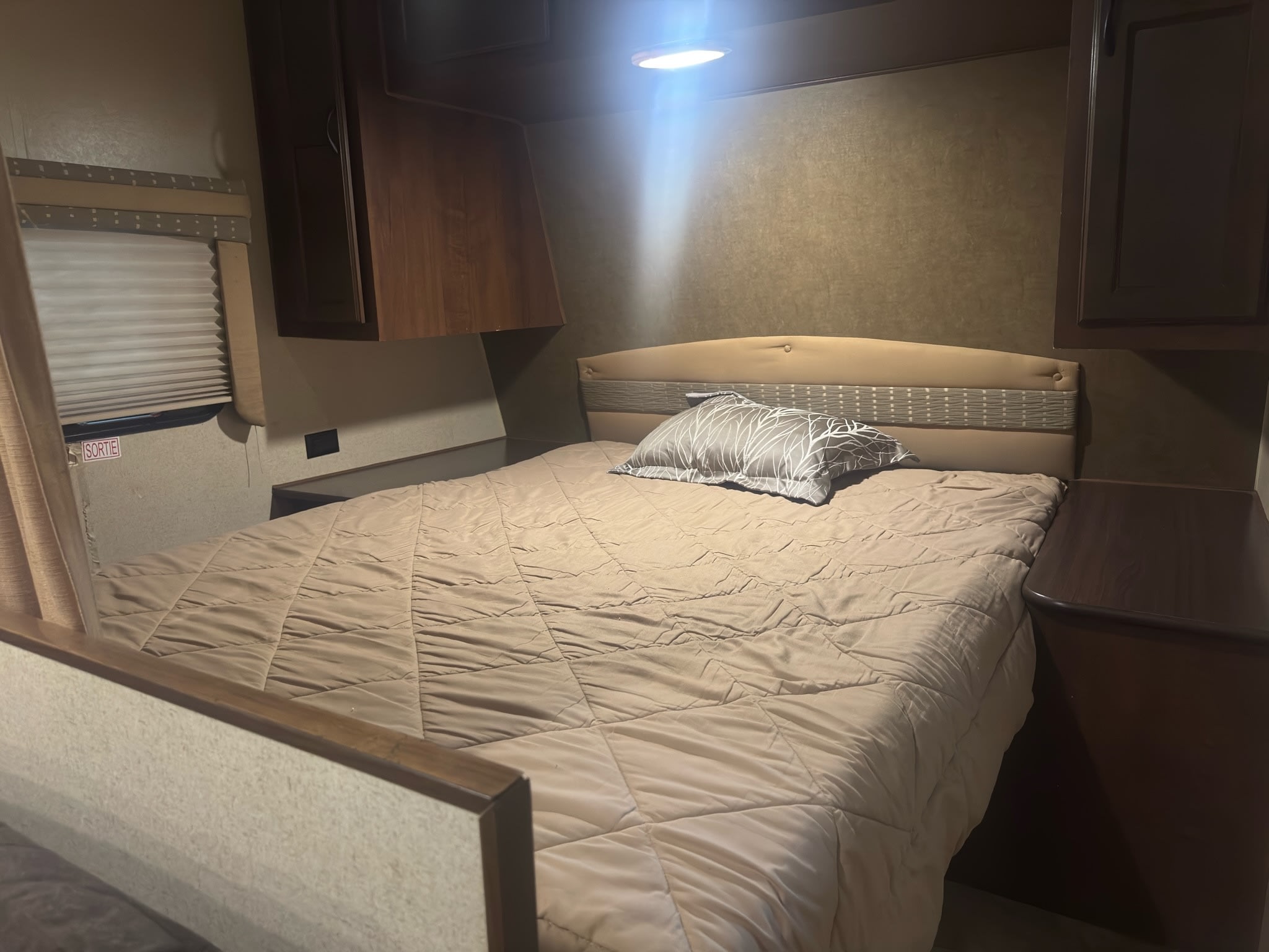 Cozy rv rental bedroom interior with a bed, storage cabinets, and a window. Ideal for comfortable camper adventures.. Jayco Jay Flight 2015