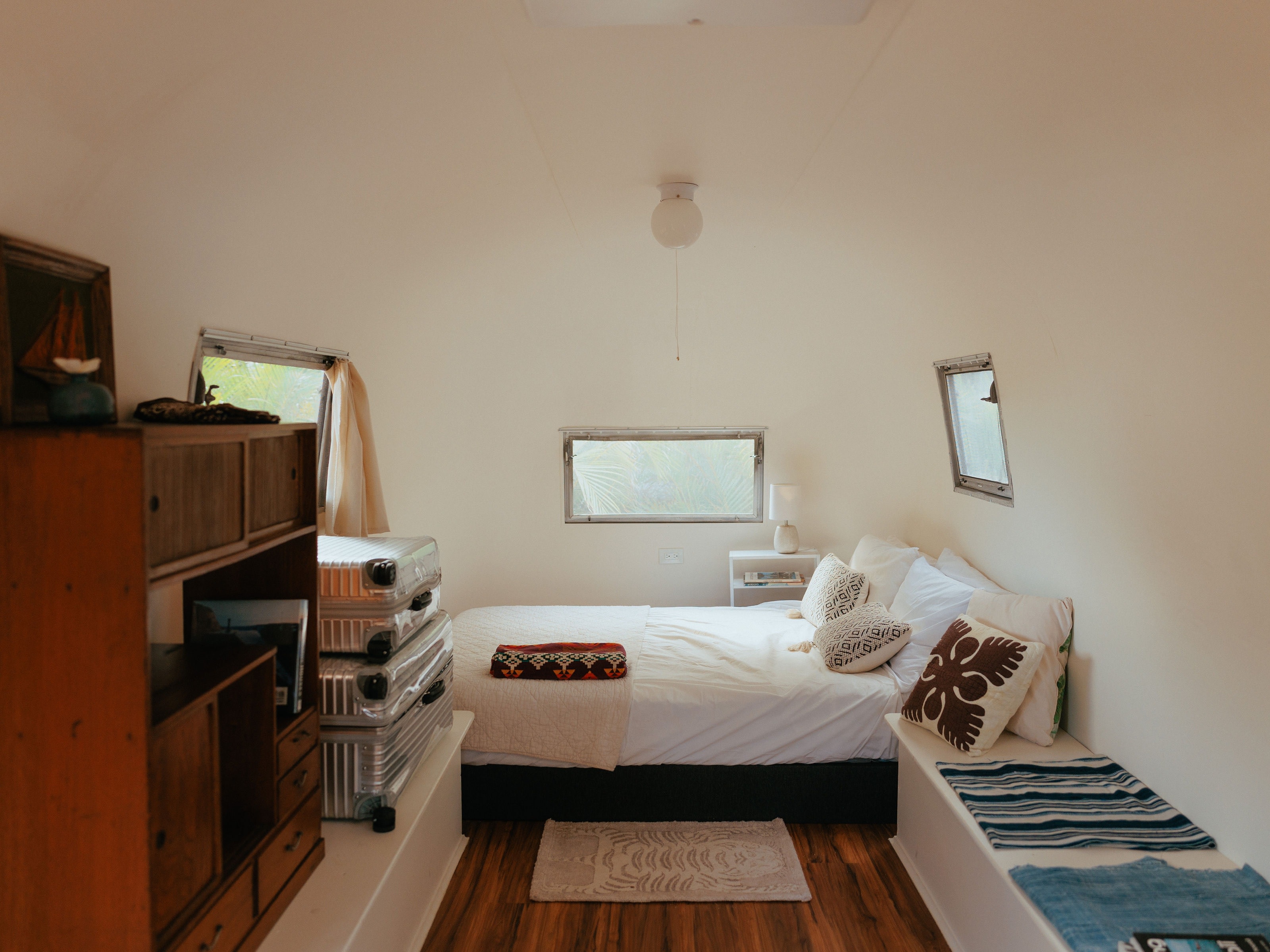 Stylish RV rental bedroom interior with a comfy bed, wood floors, and warm decor, ideal for travel.. Airstream Land Yacht 1960