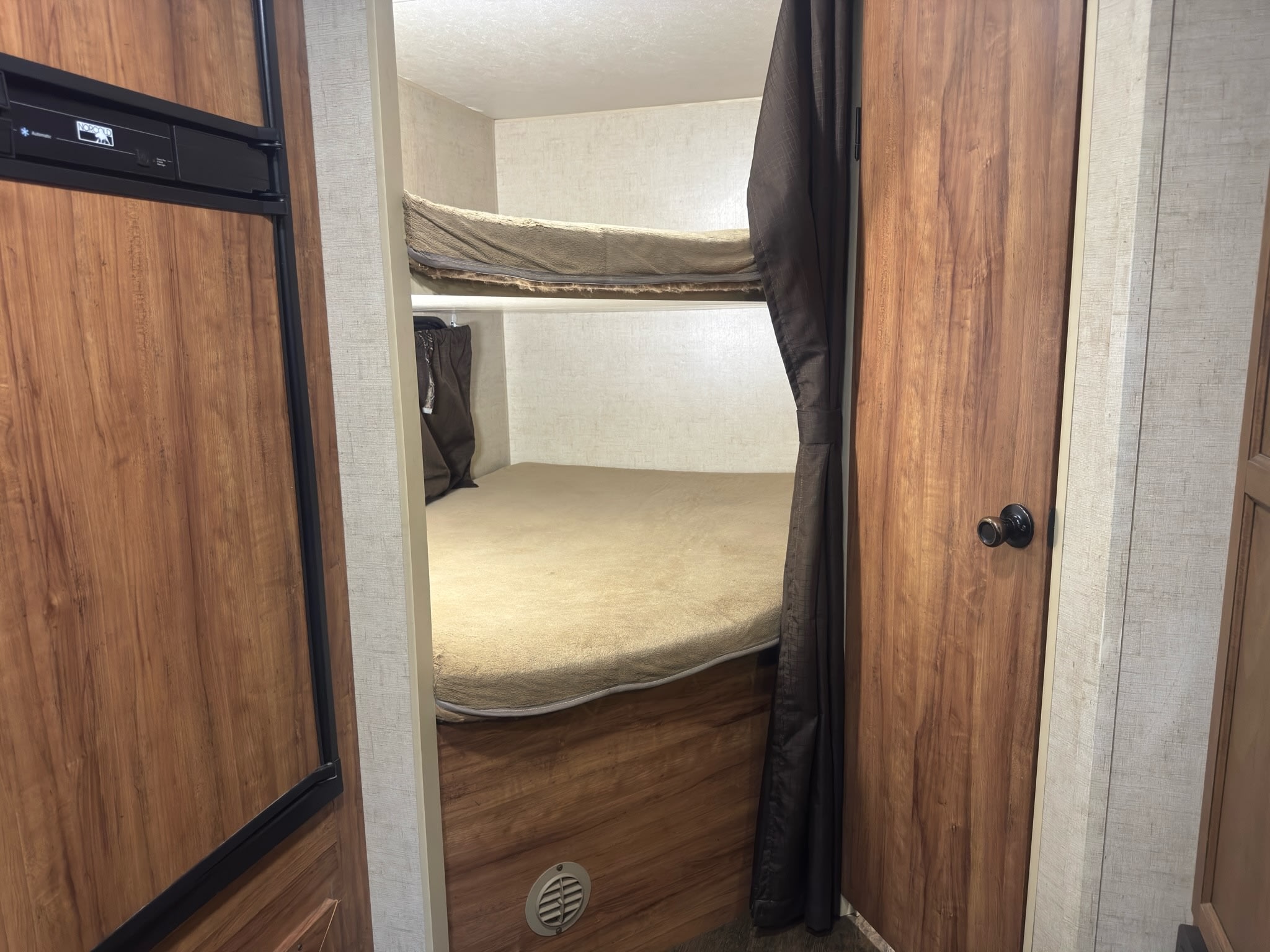 RV rental: Compact interior featuring bunk beds, a Norcold refrigerator, and wood-paneled walls for a cozy stay.. KZ C250BHS 2015
