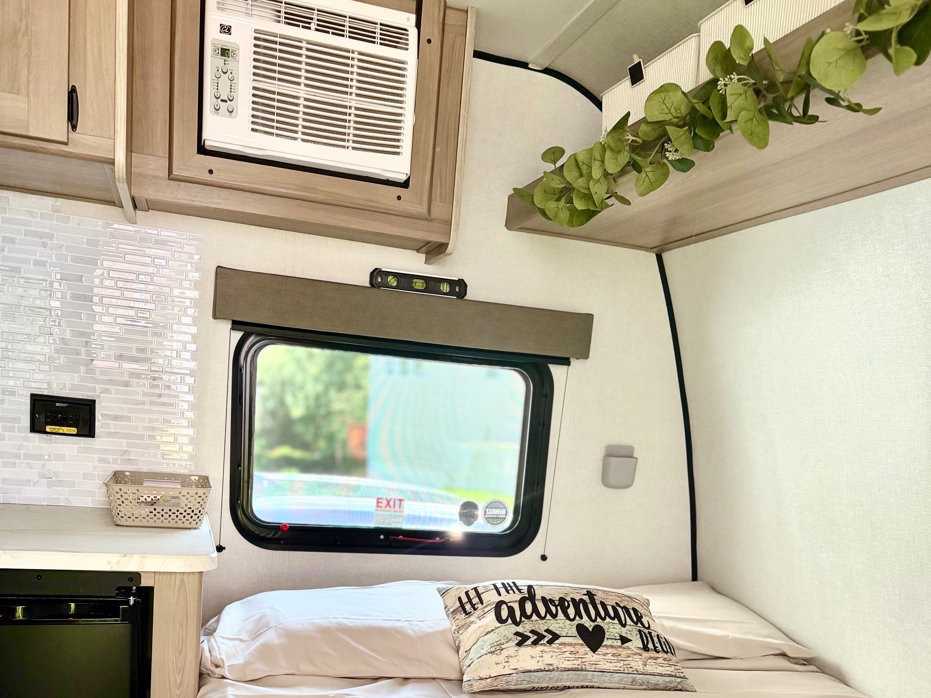 Cozy RV rental interior with a comfortable bed, window, AC, and small kitchen setup. Perfect for your next adventure!. Keystone RV Coleman 2026