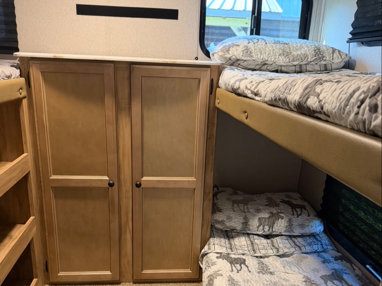 RV rental interior: cozy bunk beds with moose-themed bedding & light wood storage cabinets. Ideal for family trips.. Coachmen Coachmen Freedom Express Ultra Lite 292BHDS 2019