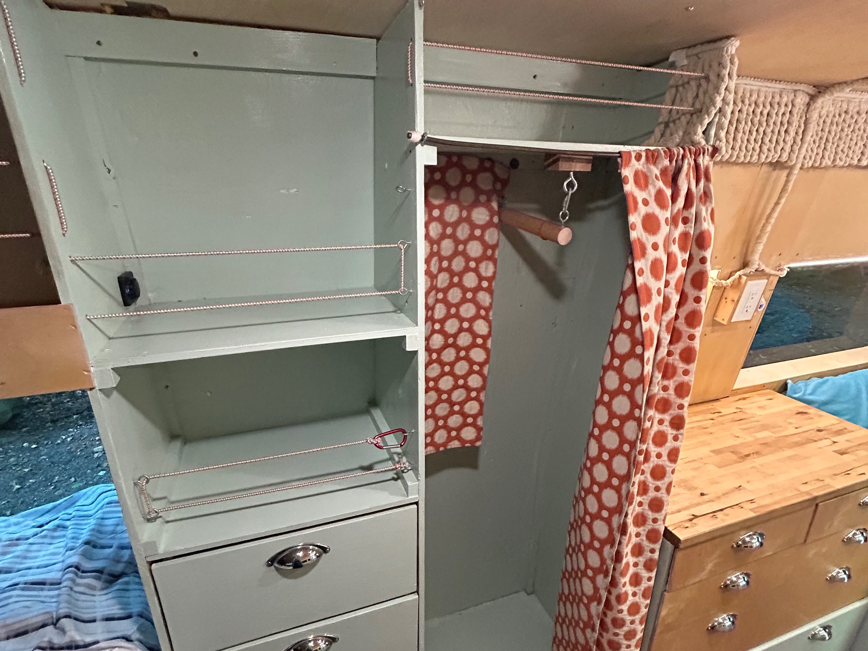 RV rental interior: Custom green cabinets, shelving, and a polka-dot curtained wardrobe offer smart storage.. Dodge Sprinter 2005