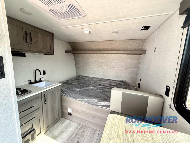 Cozy RV rental interior: features a compact kitchen, bed area, and dinette, ideal for a travel trailer adventure.. Hideout Sport 140RE 2025