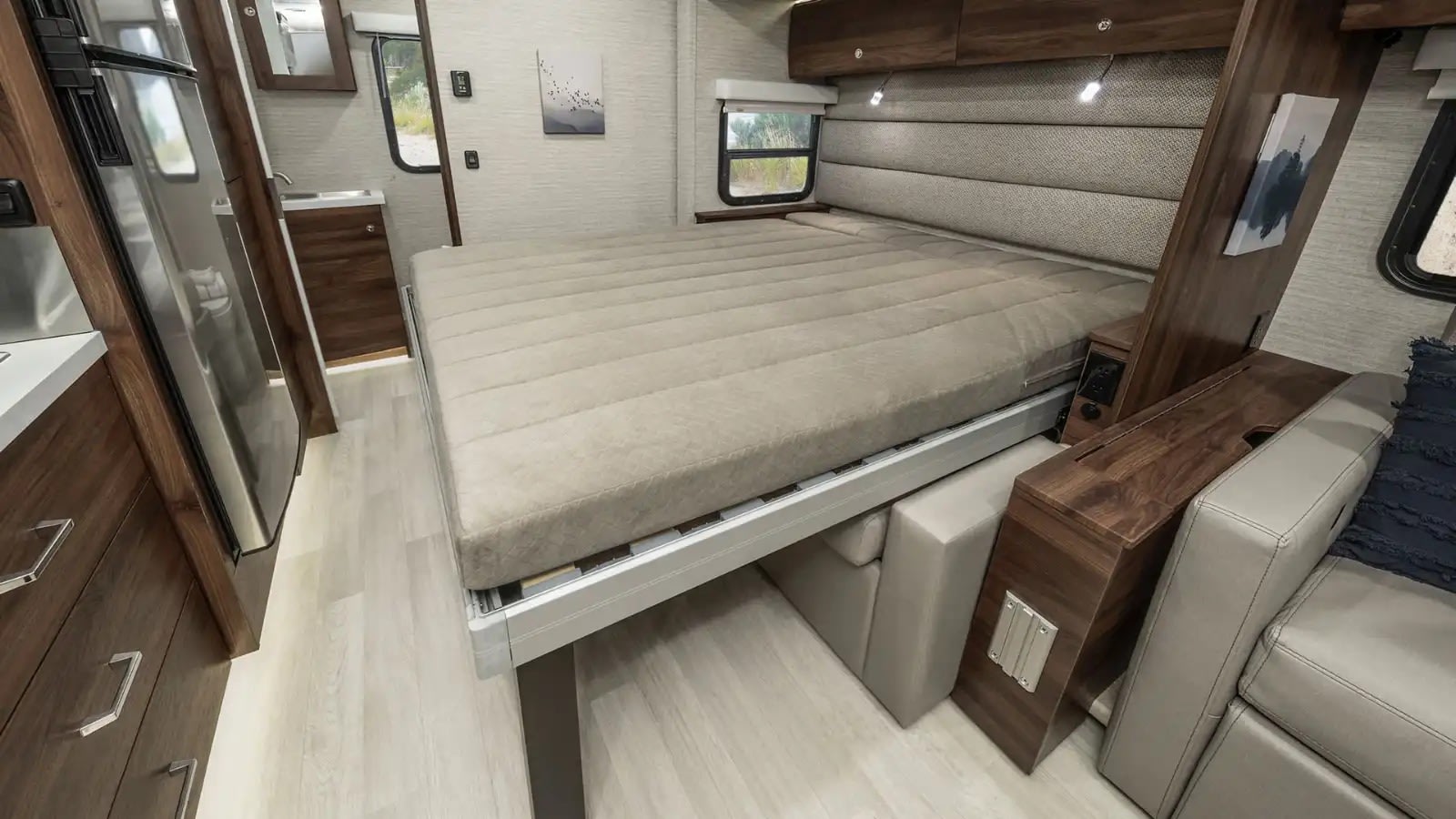 Explore this RV rental's modern interior, featuring a convertible bed, compact kitchen, and cozy lounge area.. Winnebago Navion 2023