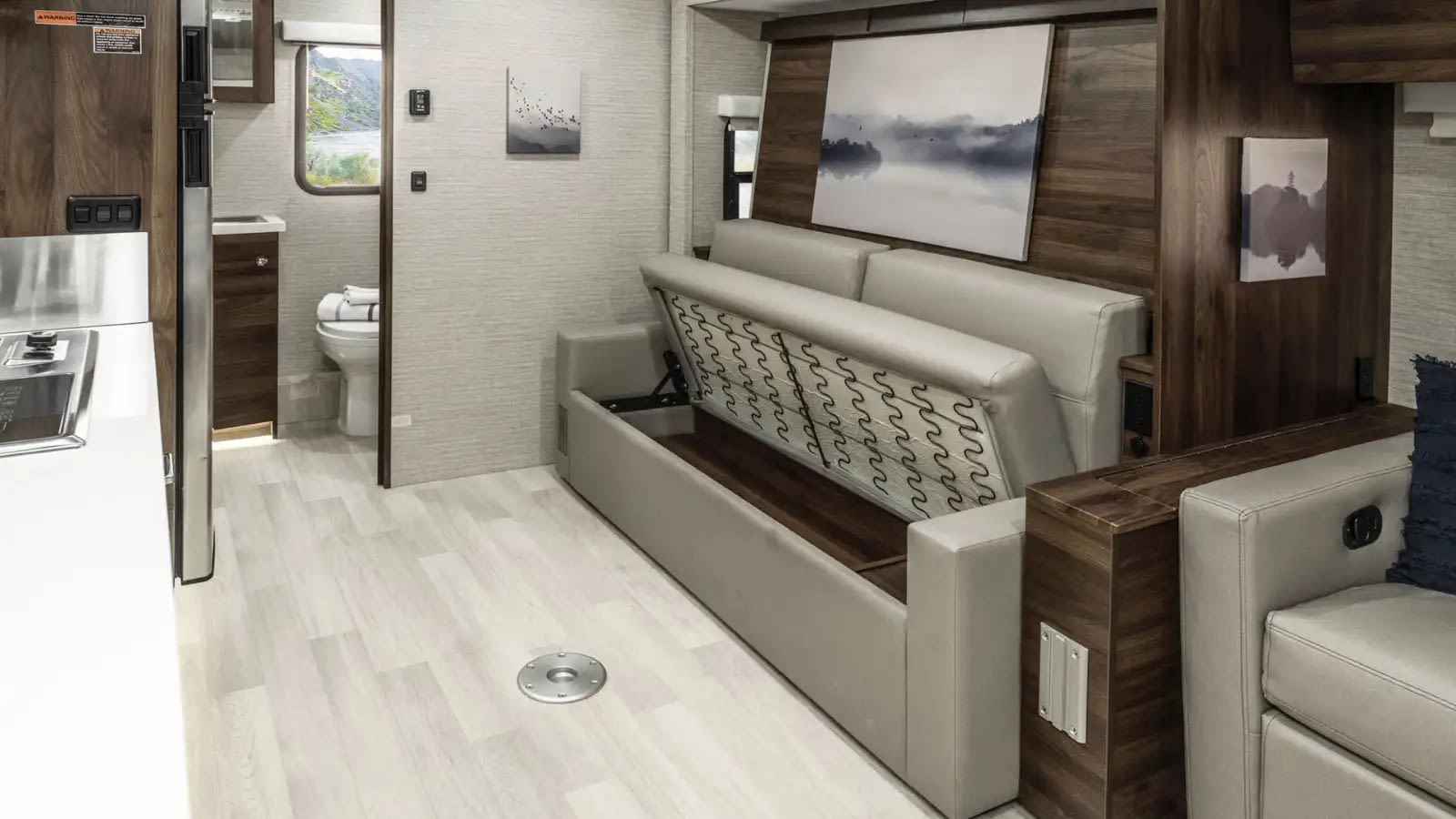 Modern rv rental interior with a versatile sofa bed, compact kitchen, and bathroom. Perfect for travel adventures!. Winnebago Navion 2023
