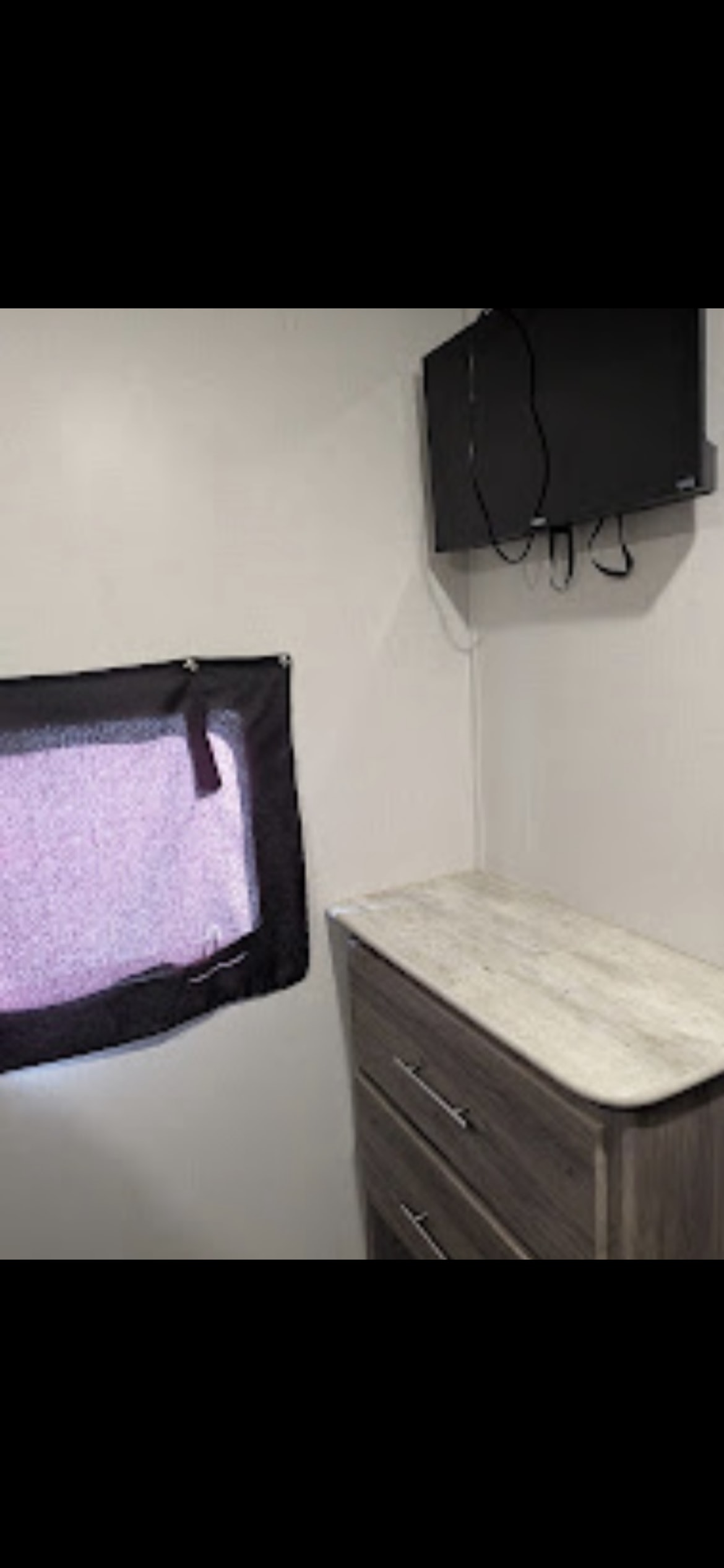 RV rental interior features: A corner view reveals a window with a blind, a wall-mounted TV, and a two-drawer dresser.. Cross Roads Zinger 2021
