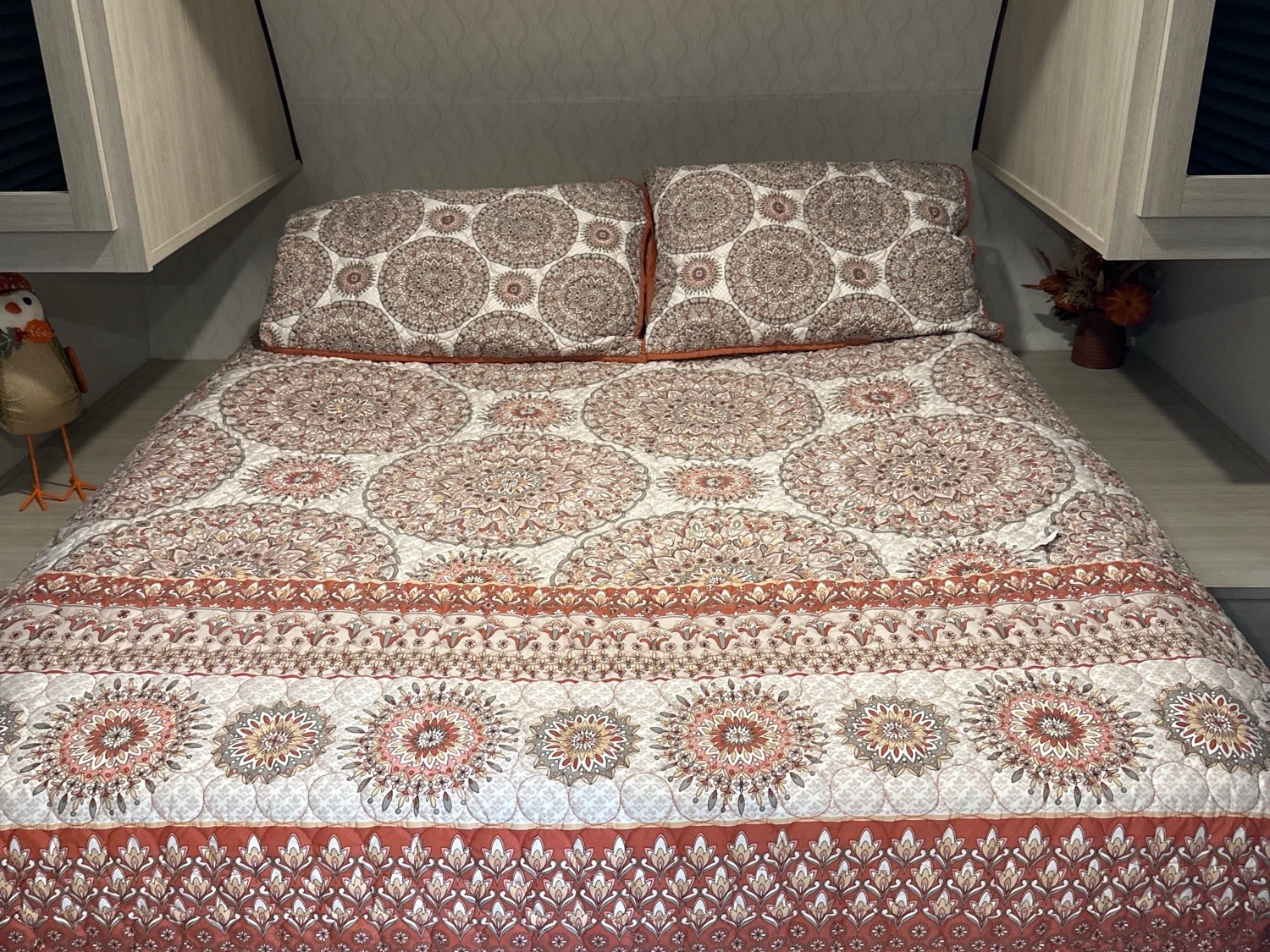 Cozy RV rental bedroom featuring a comfy bed with an intricate, earthy-toned mandala quilt design.. Forest River Palomino Puma Camping Edition 2025
