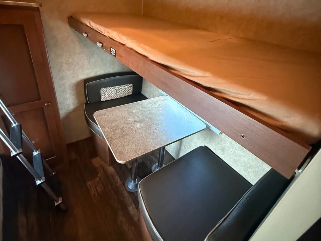 RV rental interior showing a bunk bed above a dinette with seating, table, and a ladder for bunk access.. Aspen Trail Aspen Trail Trailer 2014