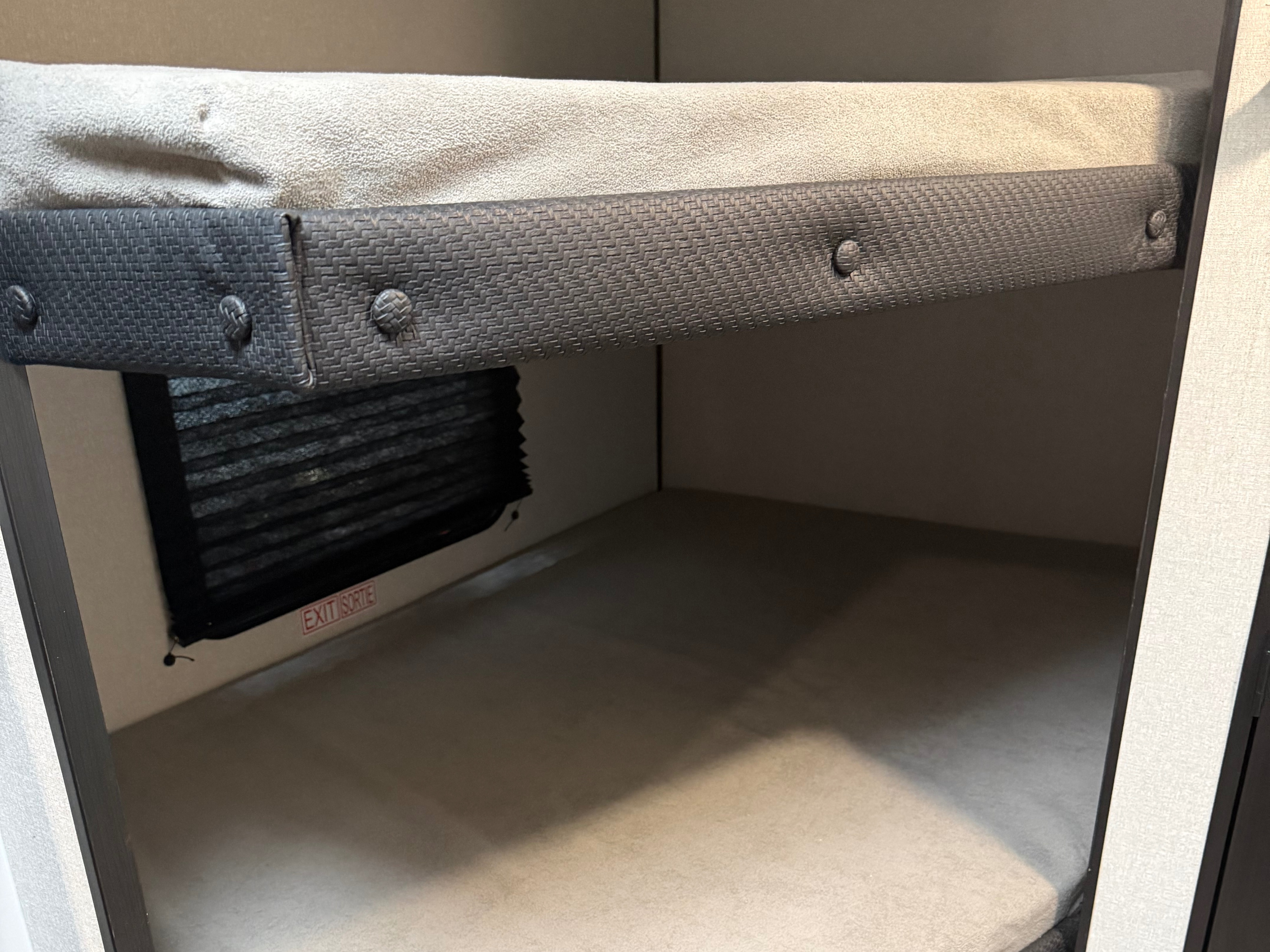 An RV rental features a cozy bunk bed sleeping area with a safety rail and window. The lower bunk has an exit sign.. Jayco Jay Flight SLX Sport Edition 2026