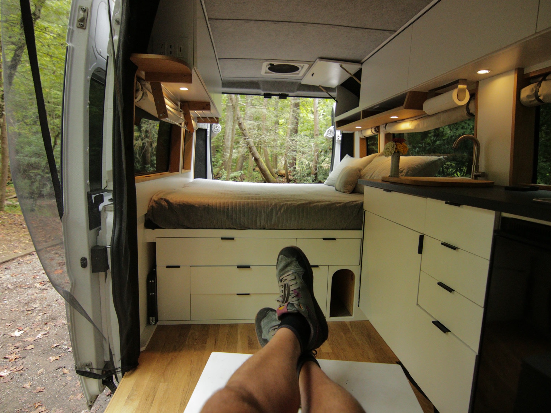 Stylish rv rental van interior: bed, kitchenette, storage. Enjoy forest views with feet up in this cozy mobile home.. Dodge Sprinter Van 2016