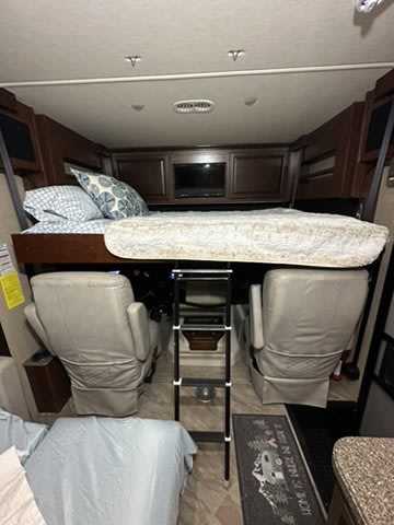 RV rental bunk bed sleeping area with a ladder above the front cabin seats, offering compact lodging.. Fleetwood Other 2017