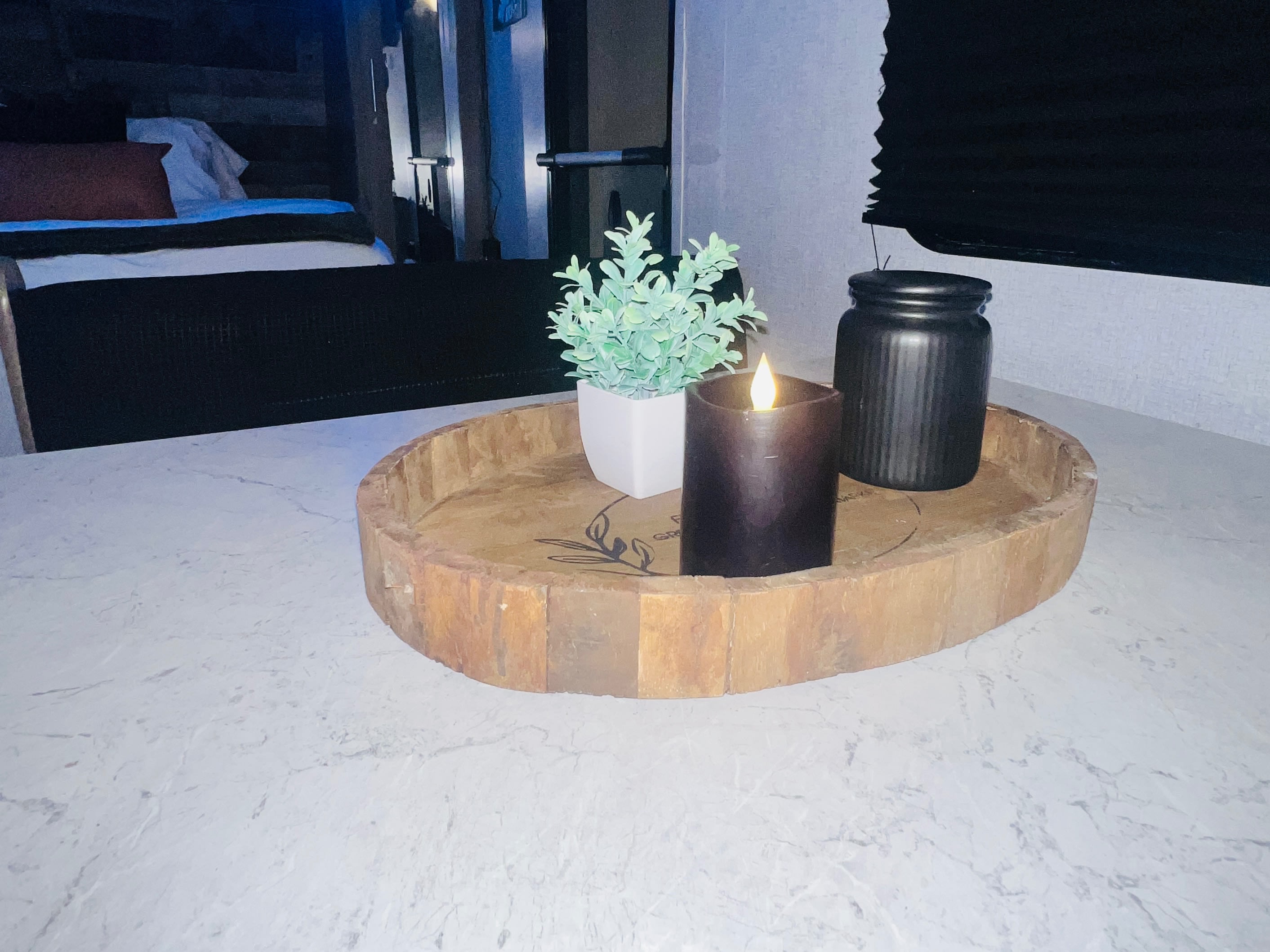 Cozy RV rental interior decor: a countertop display with a rustic tray, artificial plant, LED candle, and black jar.. Aspen Trail Aspen Trail Trailer 2020