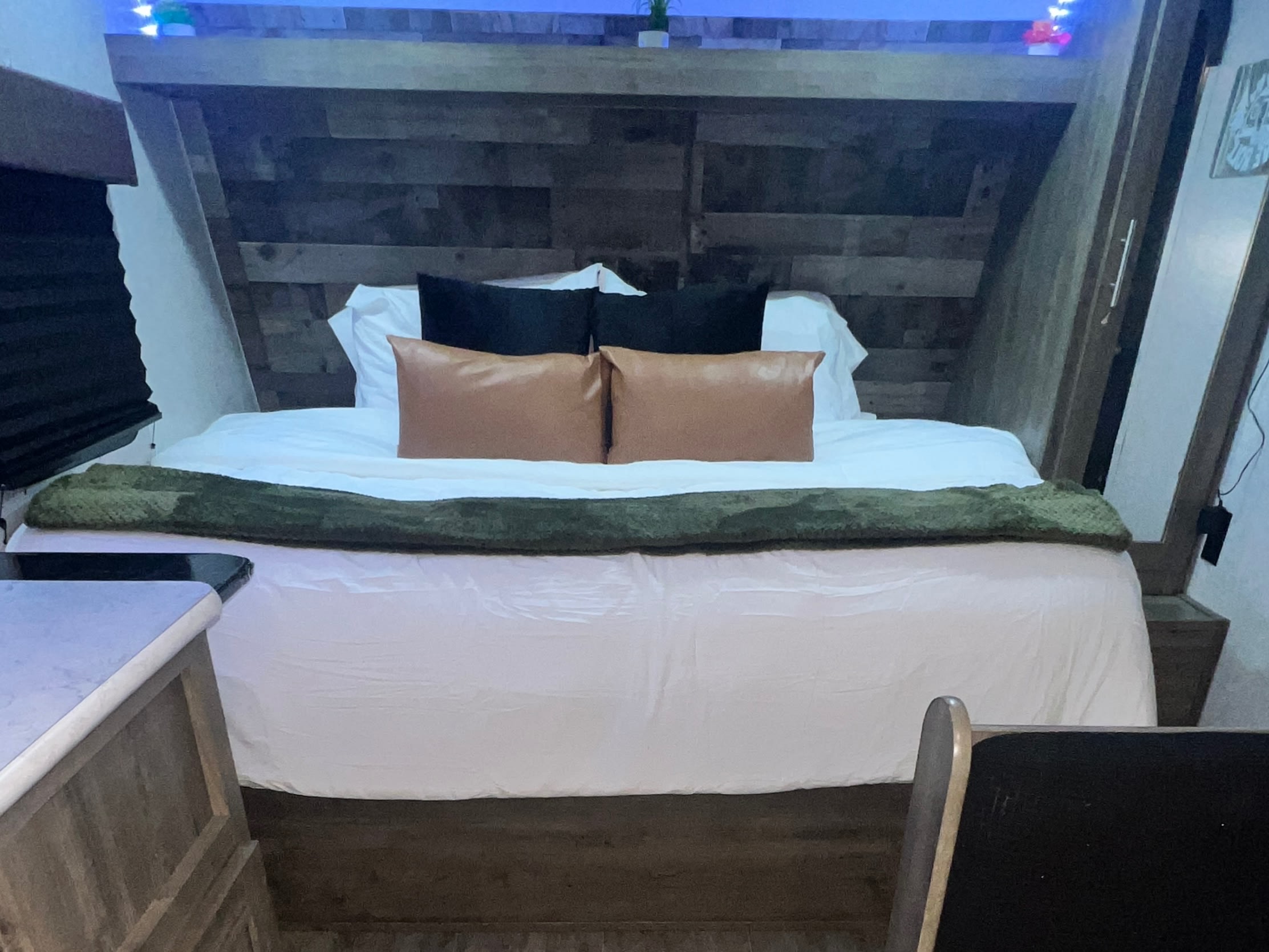 Inviting RV rental bedroom with a comfy bed, white linens, and rustic wood accents for a cozy travel stay.. Aspen Trail Aspen Trail Trailer 2020