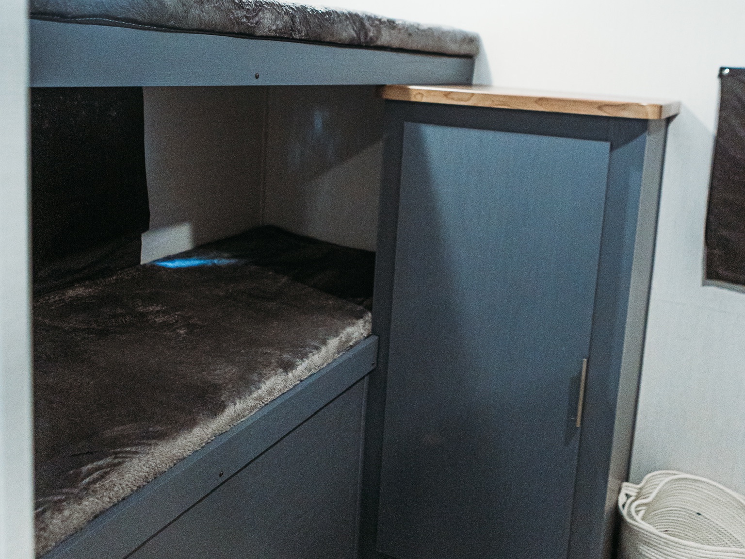 RV rental interior: cozy bunk beds with furry mattresses & a dark gray cabinet with wooden top.. Forest River Tracer 2024