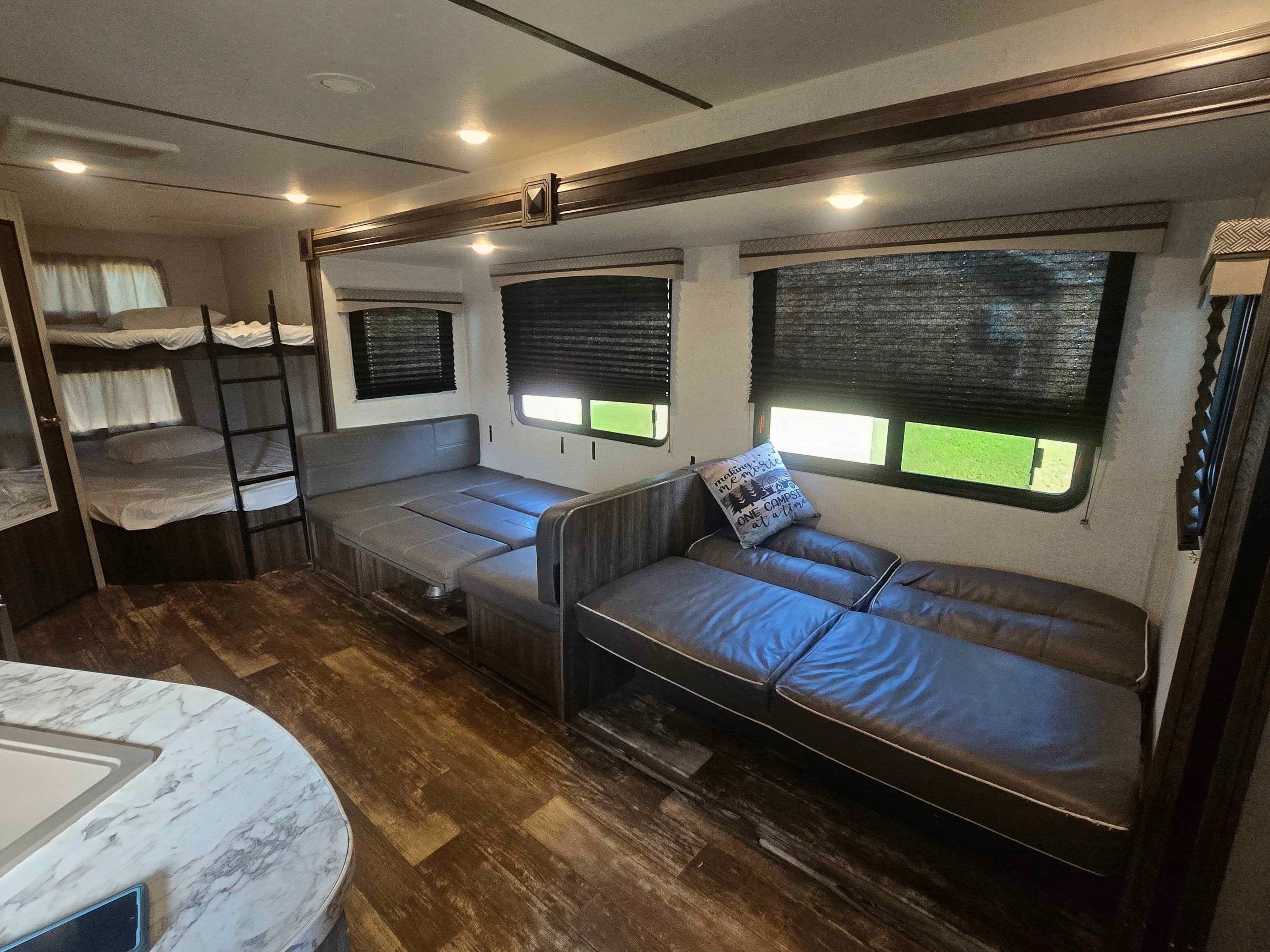 Cozy RV rental interior featuring bunk beds, a convertible dinette, and a comfy sofa, offering versatile living space.. Starflyer Starcraft 2020