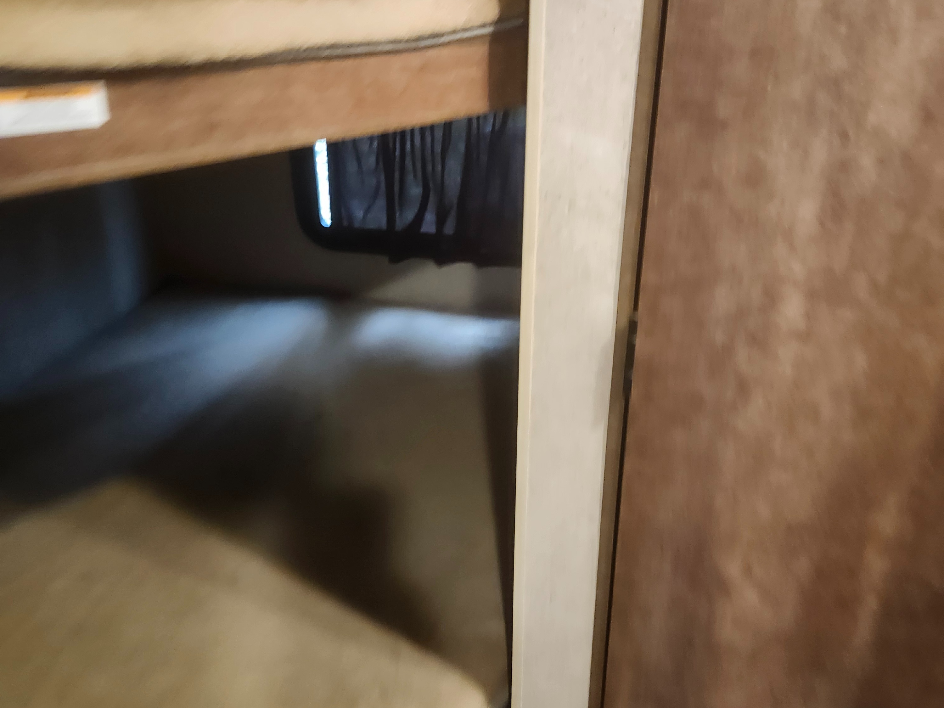 RV rental bunk bed sleeping area, showing lower and upper bunks and a window with a curtain in a compact space.. Starcraft Autumn Ridge 2018