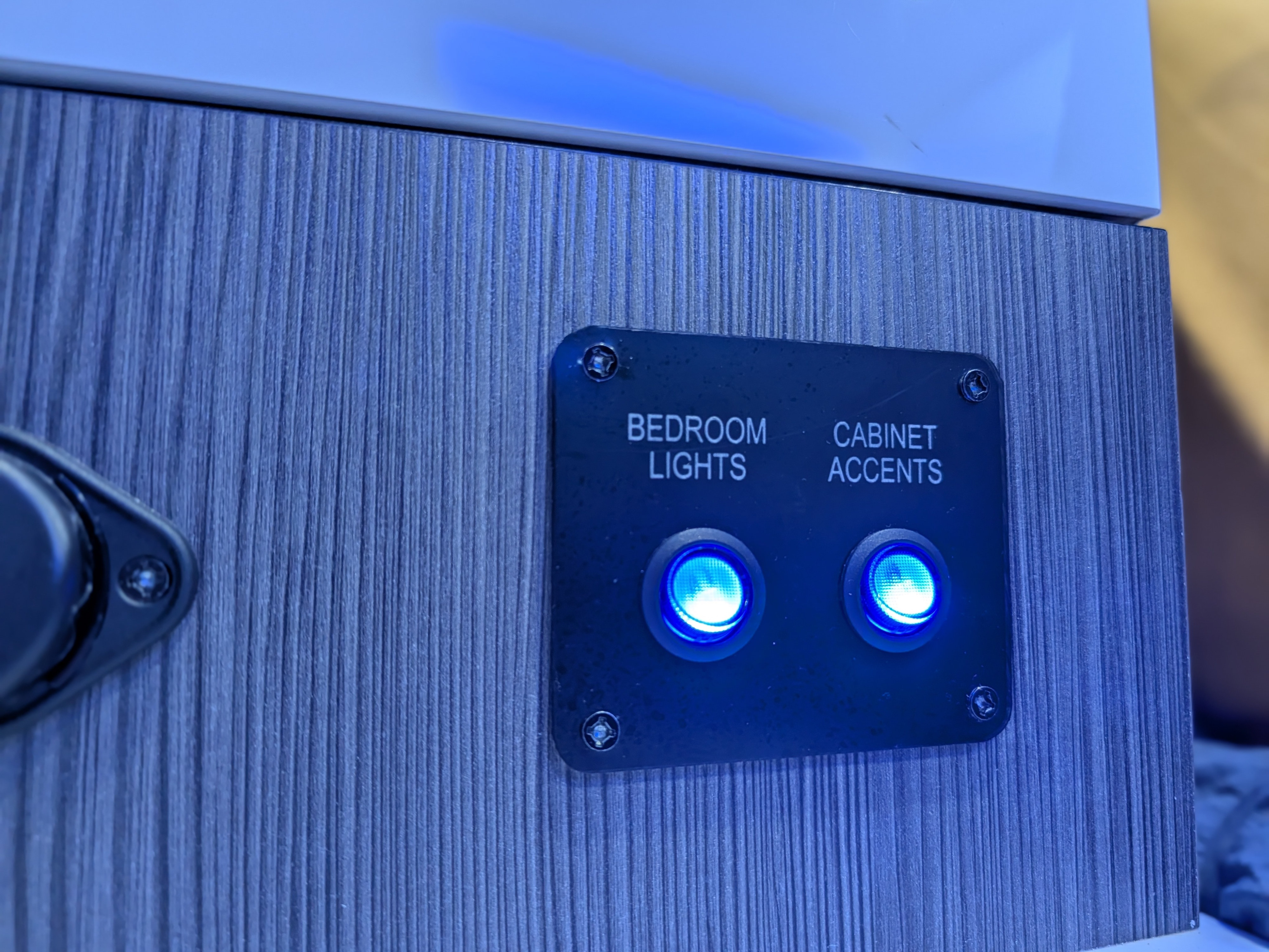 RV rental control panel with "Bedroom Lights" and "Cabinet Accents" buttons, both illuminated blue, for interior lighting.. InTech RV Aucta Magnolia 2024