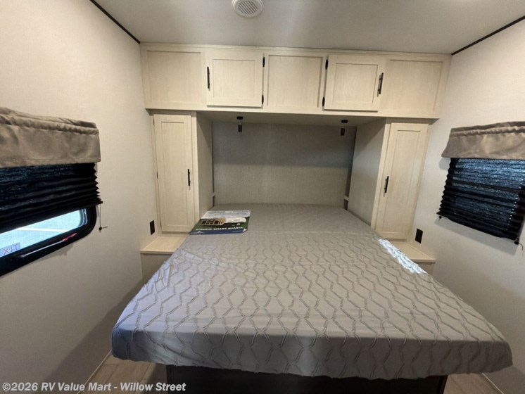 Bright RV rental bedroom with a comfy queen bed, overhead cabinets, and side storage, perfect for your next adventure.. Coachmen Shasta 2027