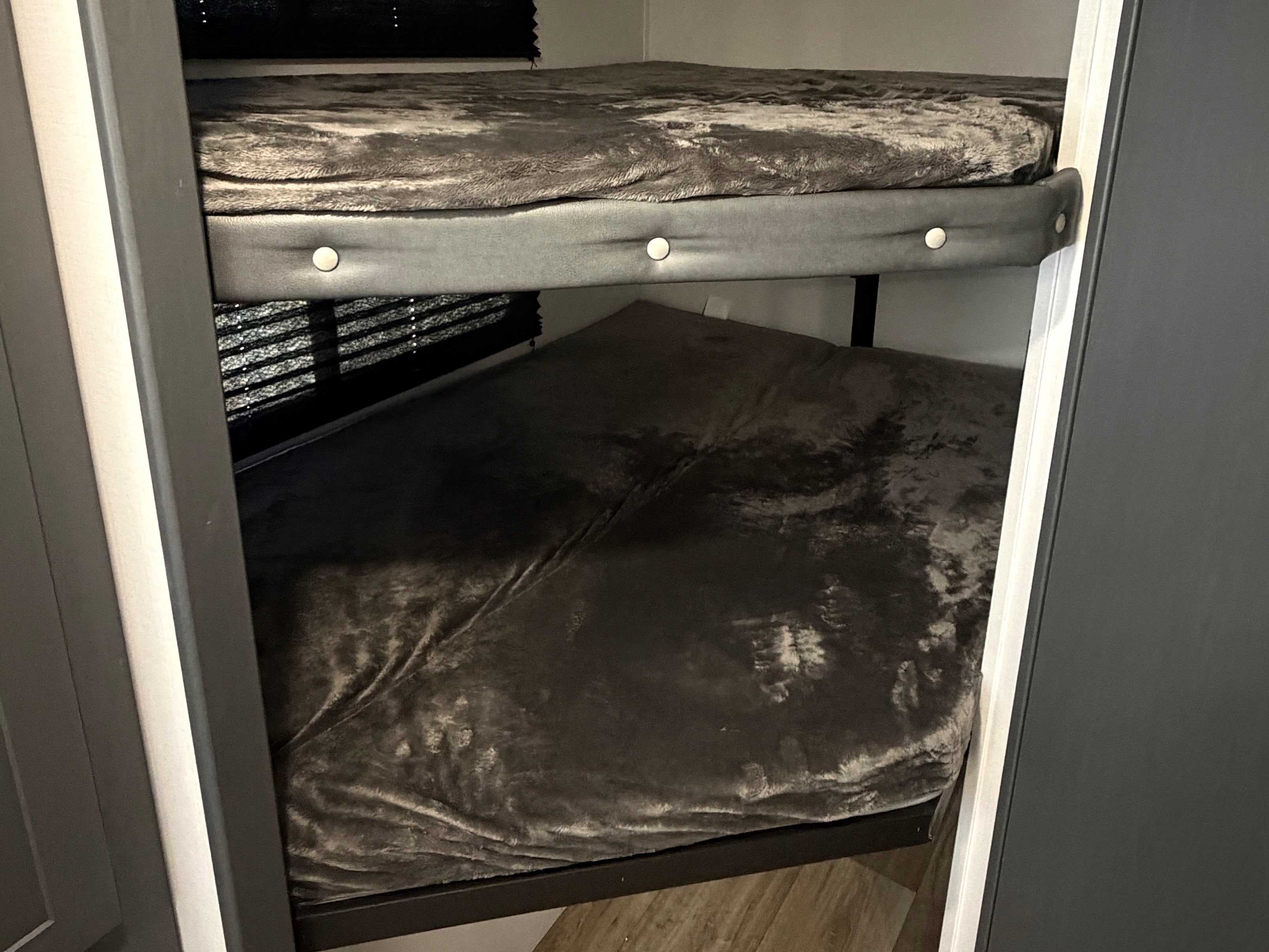 Compact dark grey bunk beds within an RV rental, designed for efficient and comfortable sleeping.. Keystone RV Bullet Crossfire 2024