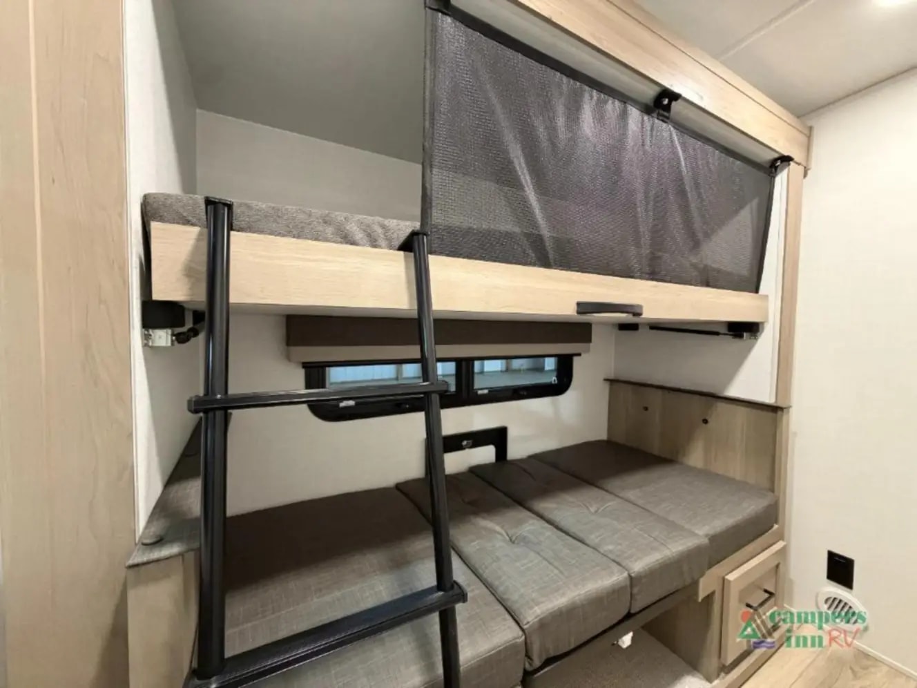 Inside an RV rental bunkhouse: A cozy top bunk with safety net, ladder, and a convertible lower bed with window.. Forest River Rockwood Mini Lite 2025