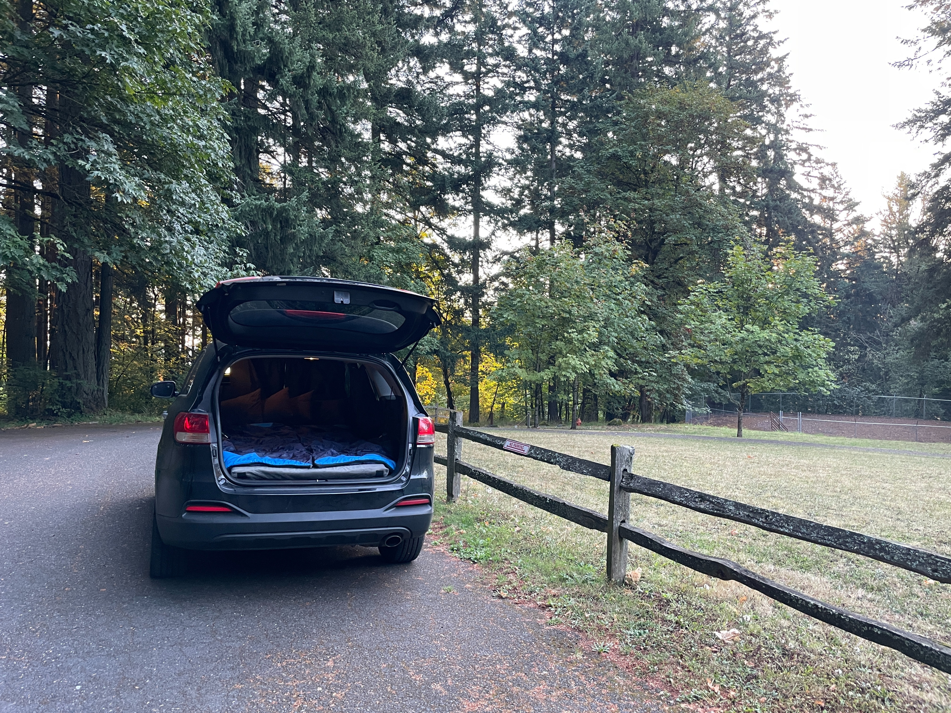 SUV car camping setup in a forest, offering an alternative to an RV rental for outdoor adventures.. KIA Sorento 4X4 2017