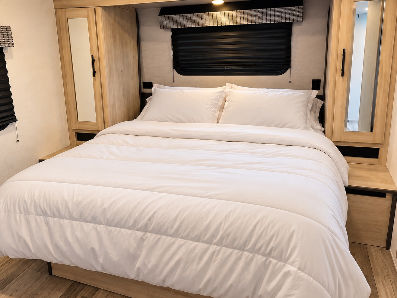 Cozy RV rental bedroom with white bedding, mirrored wardrobes, and window blinds, perfect for comfortable travel.. KZ C312BHKSE 2022