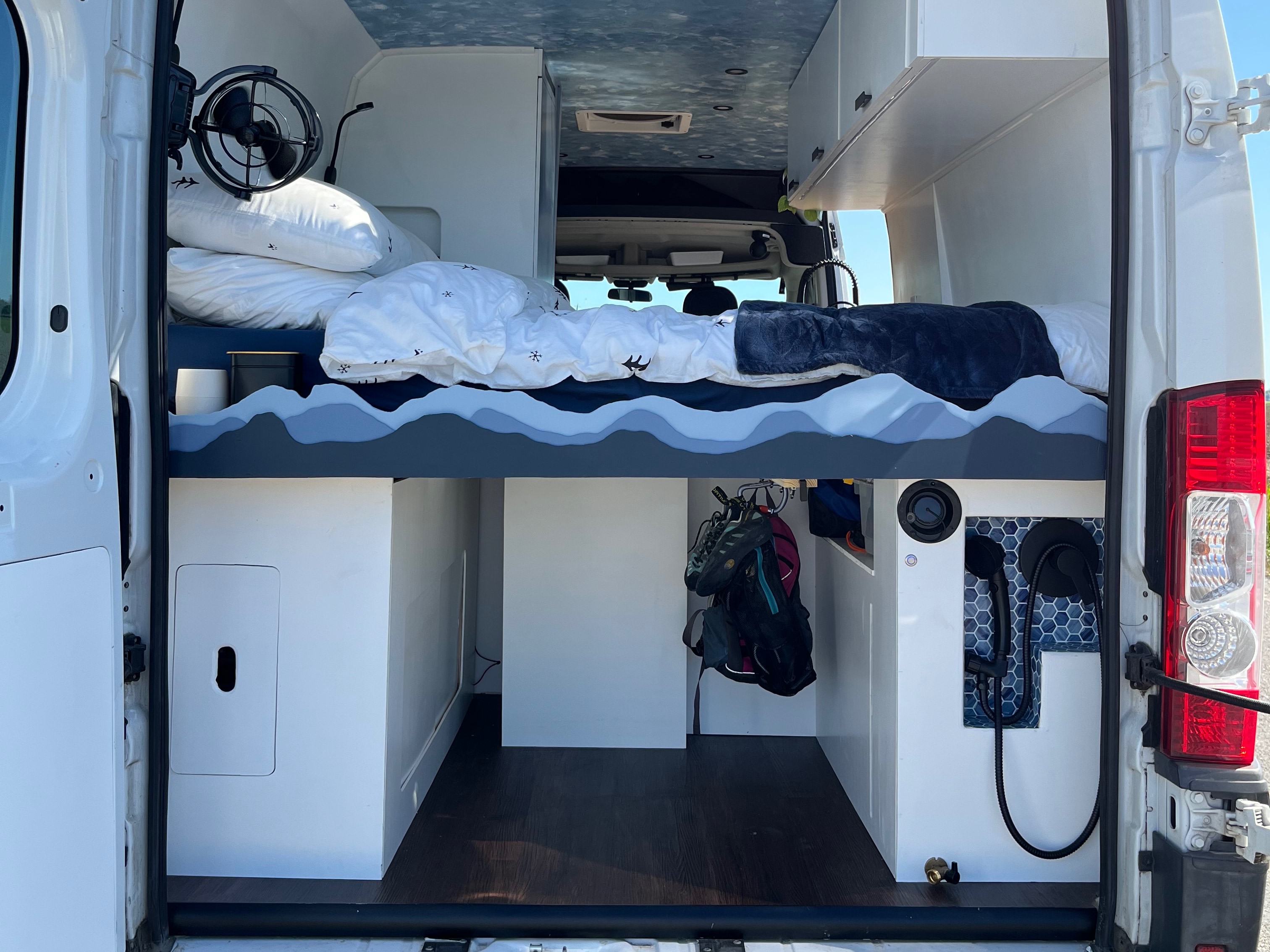 RV rental: Van interior with a cozy bed, under-bed storage, and tiled shower, offering comfort for mobile adventures.. Dodge Ram Promaster 2500 2014