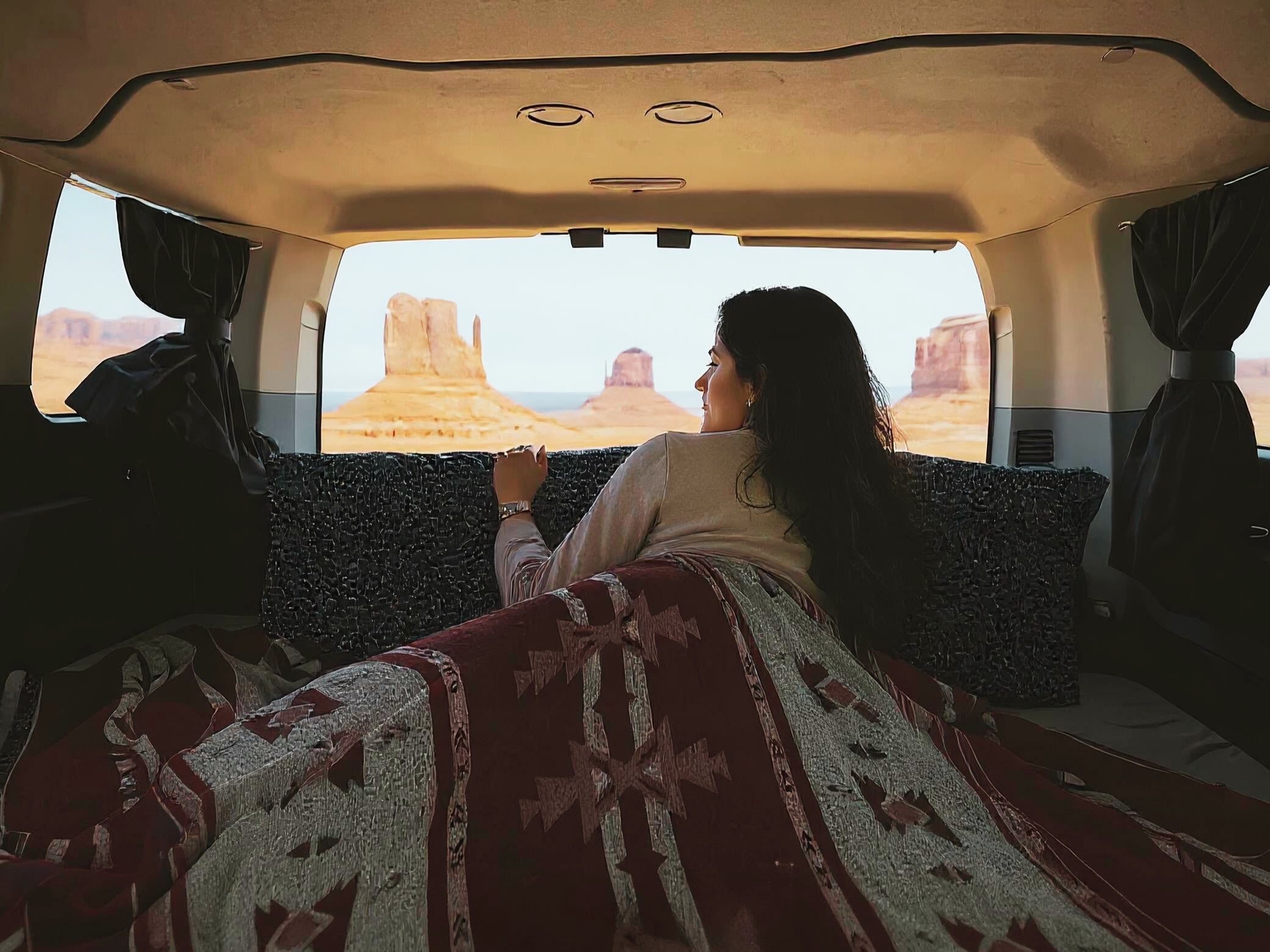 Relaxing in an RV rental, a woman enjoys the breathtaking Monument Valley desert landscape view. Ideal for scenic travel.. Ford Transit 2016