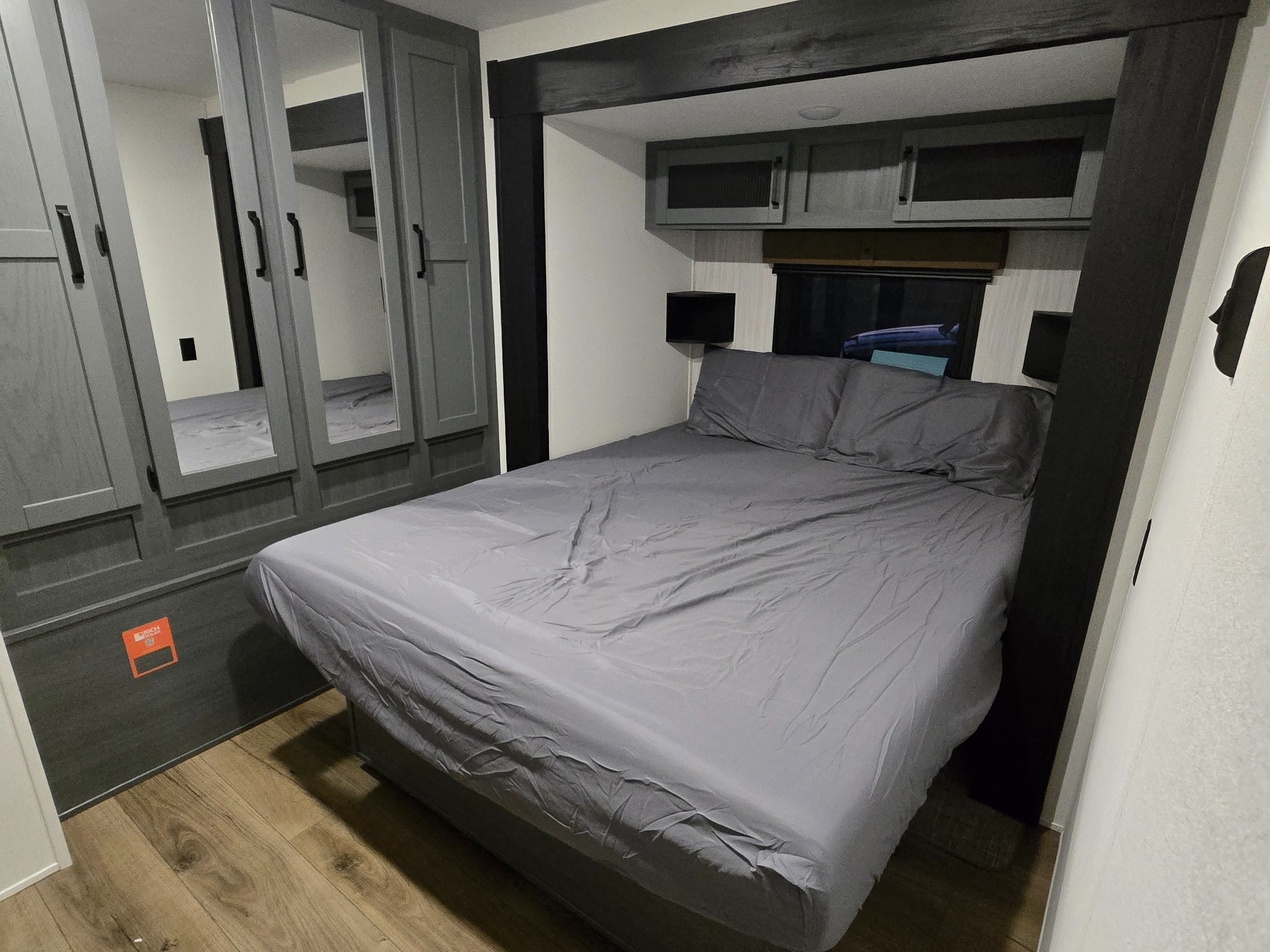 Comfortable RV rental bedroom with a full-size bed, mirrored wardrobes, and overhead cabinets for a cozy stay.. Forest River Puma 32bhqs 2027