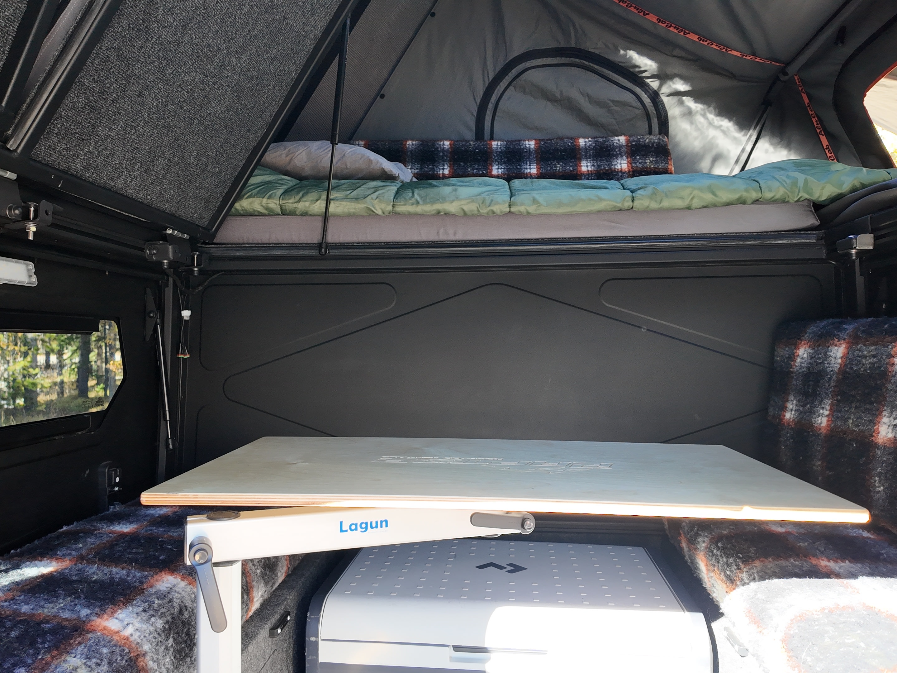 Explore with our RV rental! Functional camper interior with an overhead bed, Lagun table, and portable fridge below.. Ford Ranger 2300 Cc 2024
