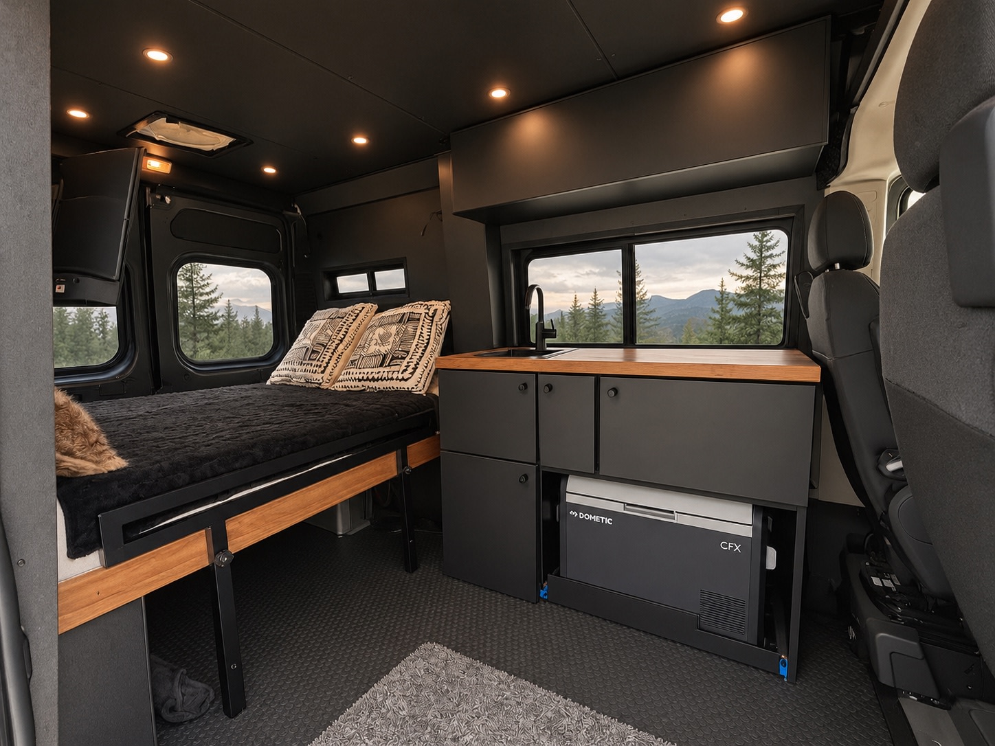Cozy RV rental interior featuring a comfortable bed, modern kitchenette with Dometic CFX fridge, and scenic mountain views.. Dodge Ram 1500 2020