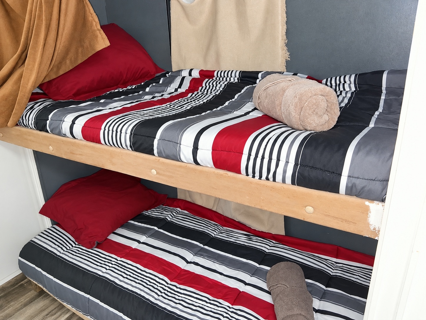 RV rental bunk beds with striped bedding, red pillows, & towels. Perfect for family adventures.. Coachman Mirada 2011