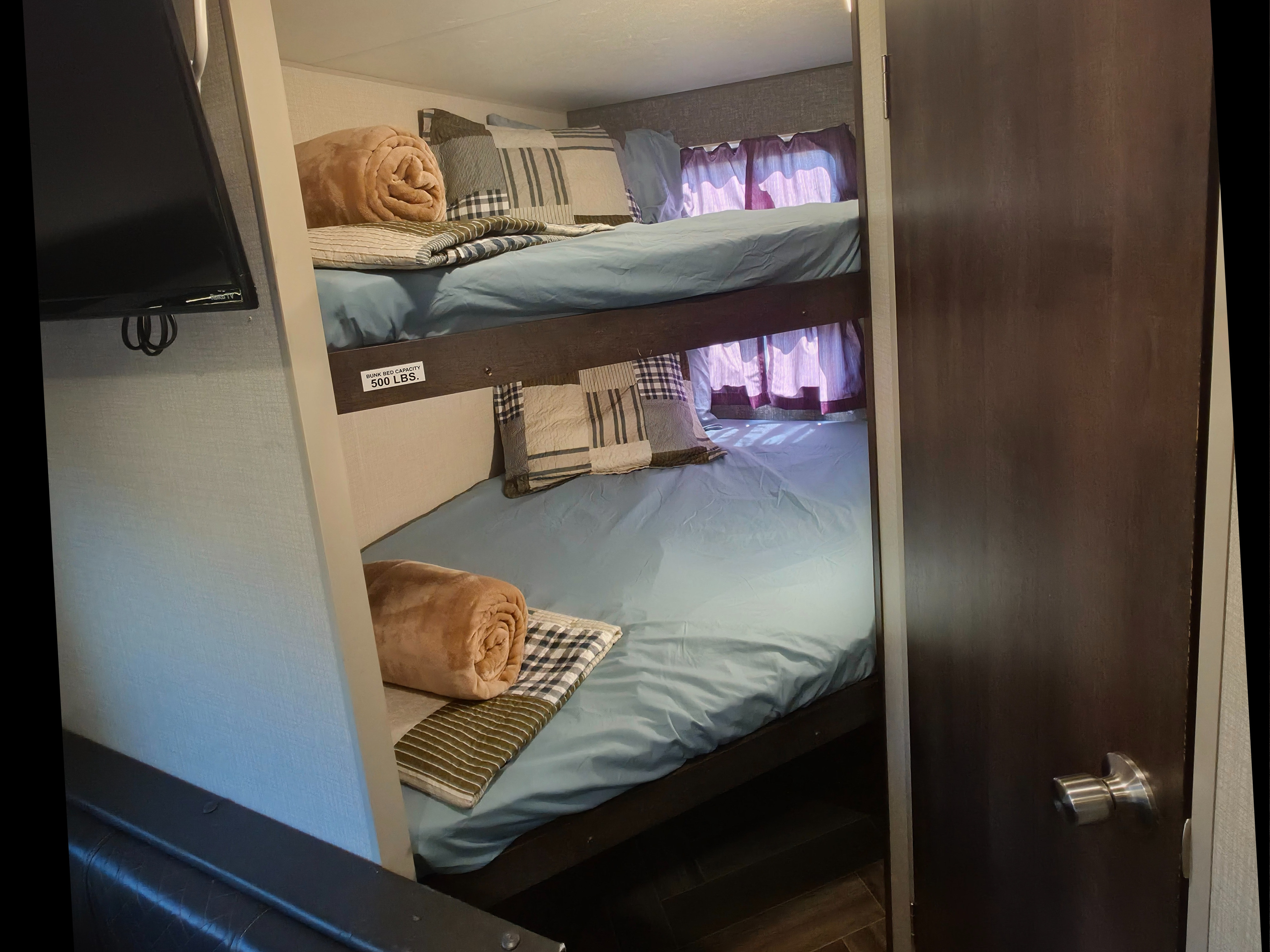 Comfortable bunk beds in an RV rental, neatly prepared with blue sheets & pillows. Upper bunk has a 500 lbs capacity.. KZ Sportsmen SE 260BHSE 2020